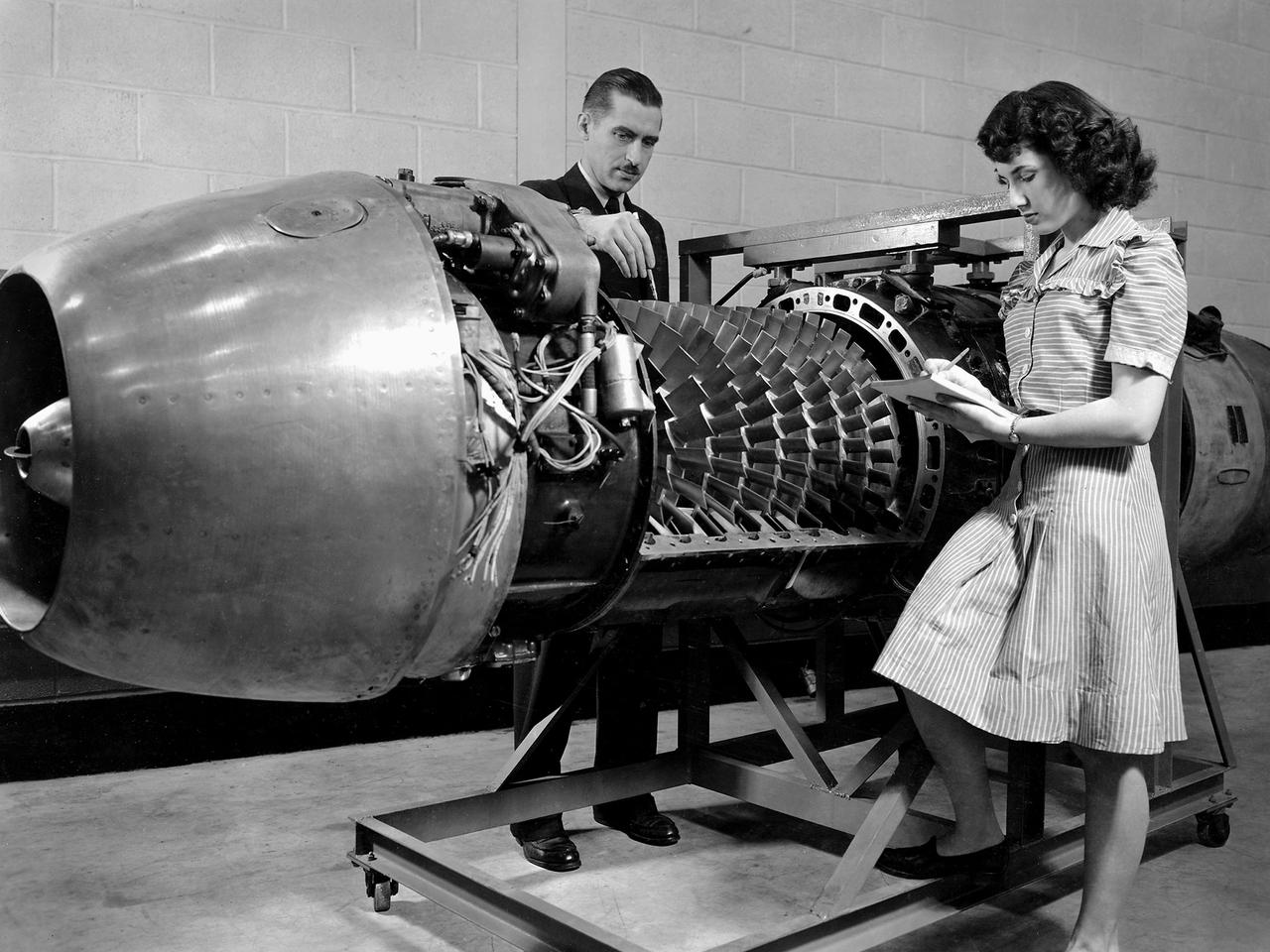 Researcher Robert Miller led an investigation into the combustor performance of a German Jumo 004 engine at the National Advisory Committee for Aeronautics (NACA) Lewis Flight Propulsion Laboratory. The Jumo 004 powered the world's first operational jet fighter, the Messerschmitt Me 262, beginning in 1942. The Me 262 was the only jet aircraft used in combat during World War II. The eight-stage axial-flow compressor Jumo 004 produced 2000 pounds of thrust.     The US Army Air Forces provided the NACA with a Jumo 004 engine in 1945 to study the compressor’s design and performance. Conveniently the engine’s designer Anselm Franz had recently arrived at Wright-Patterson Air Force Base in nearby Dayton, Ohio as part of Project Paperclip. The Lewis researchers used a test rig in the Engine Research Building to analyze one of the six combustion chambers. It was difficult to isolate a single combustor’s performance when testing an entire engine. The combustion efficiency, outlet-temperature distribution, and total pressure drop were measured. The researchers determined the Jumo 004’s maximum performance was 5000 revolutions per minute at a 27,000 foot altitude and 11,000 revolutions per minute at a 45,000 foot altitude.      The setup in this photograph was created for a tour of NACA Lewis by members of the Institute of Aeronautical Science on March 22, 1945.