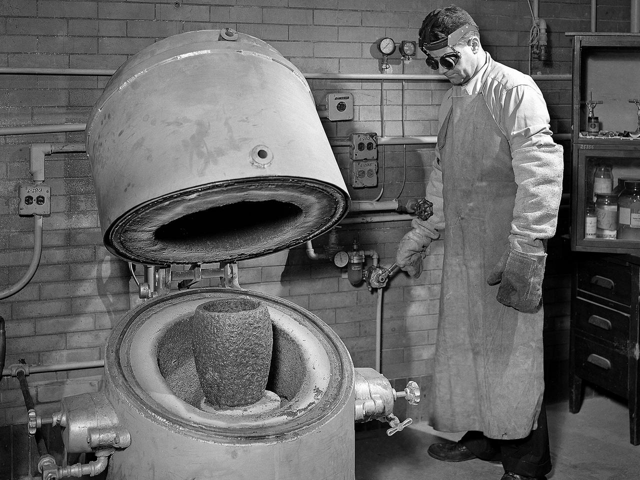A technician prepares a metal component for a high-temperature bake in the Heat Treatment Shop at the National Advisory Committee for Aeronautics (NACA) Lewis Flight Propulsion Laboratory.  Fabrication Division under Dan White and John Dalgleish created almost all of the equipment and models used at the laboratory. The Technical Services Building, referred to as the Fab Shop, contained a number of specialized shops in the 1940s and 1950s. These included a Machine Shop, Sheet Metal Shop, Wood and Pattern Shop, Instrument Shop, Thermocouple Shop, Heat Treating Shop, Metallurgical Laboratory, and Fabrication Office.   The Metallurgical Laboratory contained a control lab for the Heat Treating Shop and a service lab for the NACA Lewis research divisions. This metallurgical group performed tensile and impact tests on metals to determine their suitability for specific research or equipment. The Heat Treating Shop heated metal parts to optimize their physical properties and contained a Precision Castings Foundry to manufacture equipment made of heat resisting alloys.