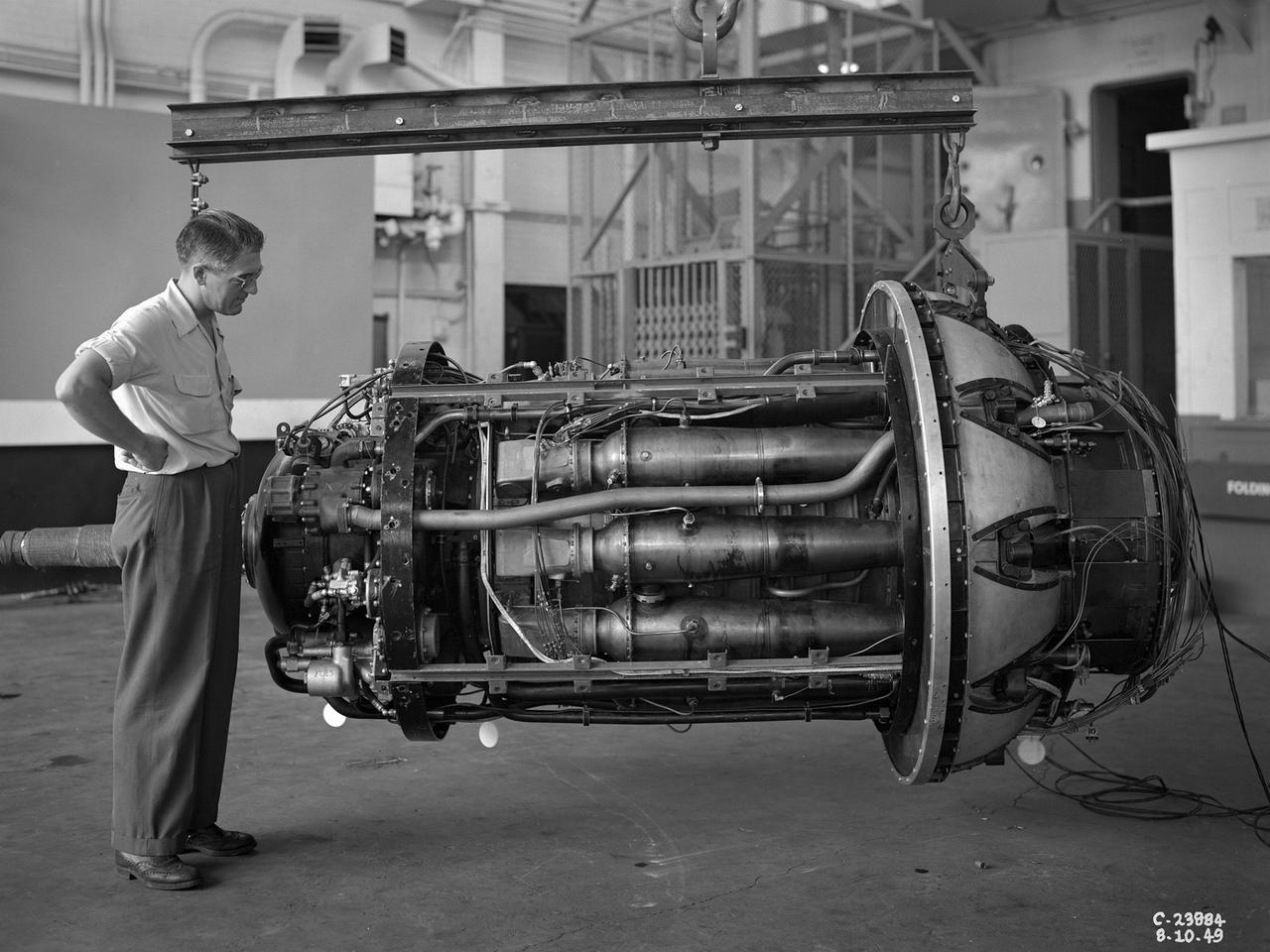 A 3670-horsepower Armstrong-Siddeley Python turboprop being prepared for tests in the Altitude Wind Tunnel at the National Advisory Committee for Aeronautics (NACA) Lewis Flight Propulsion Laboratory. In 1947 Lewis researcher Walter Olsen led a group of representatives from the military, industry, and the NACA on a fact finding mission to investigate the technological progress of British turbojet manufacturers. Afterwards several British engines, including the Python, were brought to Cleveland for testing in Lewis’s altitude facilities.     The Python was a 14-stage axial-flow compressor turboprop with a fixed-area nozzle and contra-rotating propellers. Early turboprops combined the turbojet and piston engine technologies. They could move large quantities of air so required less engine speed and thus less fuel. This was very appealing to the military for some applications. The military asked the NACA to compare the Python’s performance at sea to that at high altitudes.    The NACA researchers studied the Python in the Altitude Wind Tunnel from July 1949 through January 1950. It was the first time the tunnel was used to study an engine with the sole purpose of learning about, not improving it. They analyzed the engine’s dynamic response using a frequency response method at altitudes between 10,000 to 30,000 feet. Lewis researchers found that they could predict the dynamic response characteristics at any altitude from the data obtained from any other specific altitude. This portion of the testing was completed during a single test run.