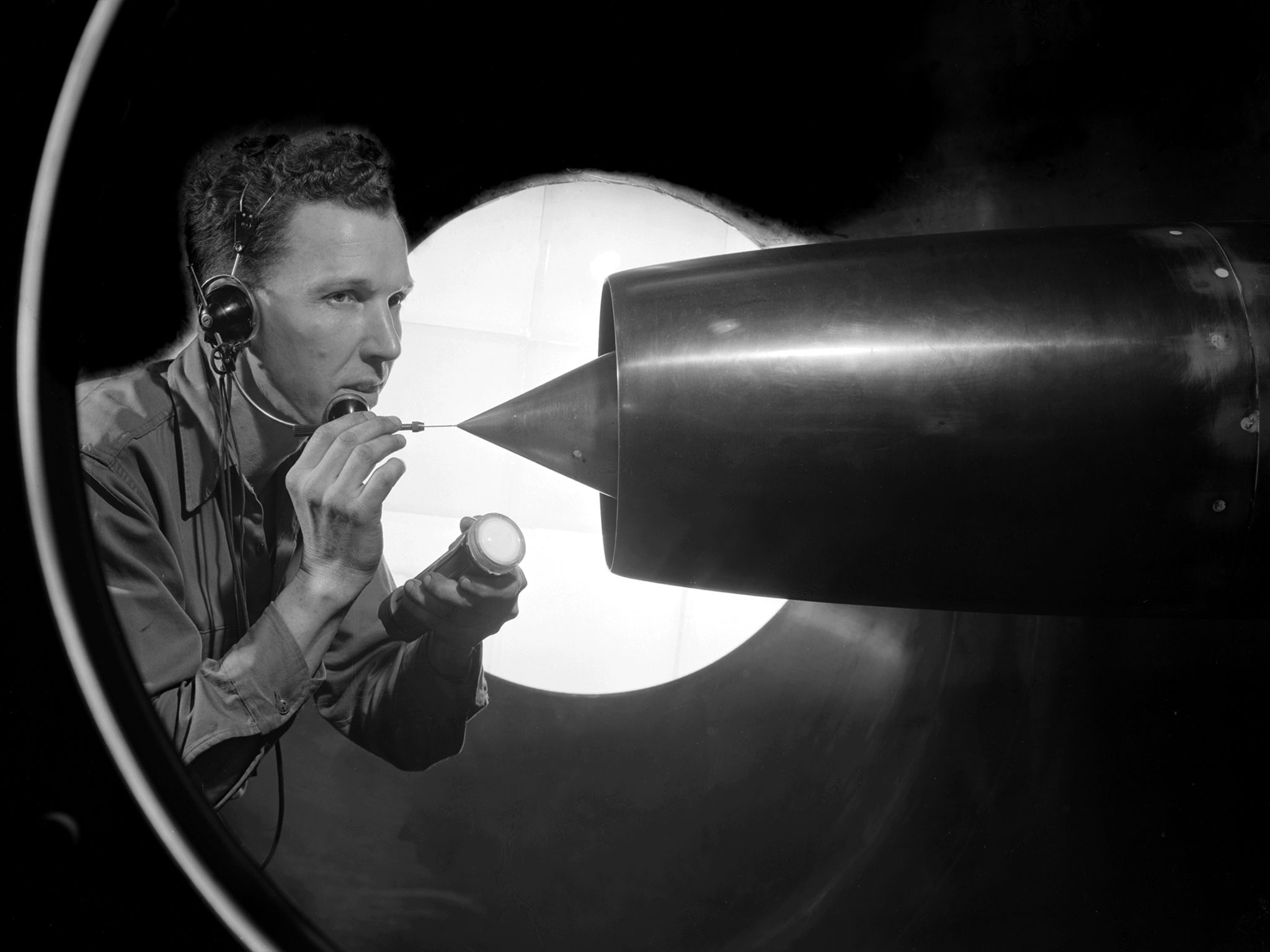 Technician cleans a pitot tube on a ramjet in a wind tunnel