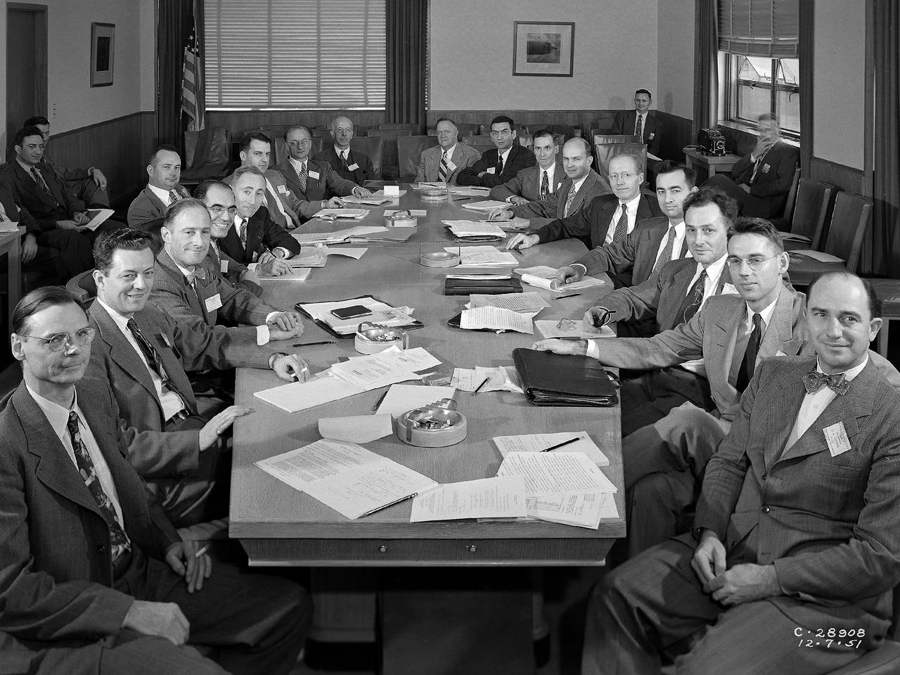 The National Advisory Committee for Aeronautics (NACA) Subcommittee on Combustion holds a meeting at Lewis Flight Propulsion Laboratory in Cleveland, Ohio. The NACA was managed by committees that included members of their own staff along with representatives from industry, the military, other government agencies, and universities. The 17-person Executive Committee was the NACA’s primary administrative body. They met several times a year at the NACA headquarters office in Washington DC to discuss broad issues confronting the US aeronautical community. Jerome Hunsaker, head of the Department of Aeronautical Engineering at the Massachusetts Institute of Technology, served as the NACA chairman from 1941 to 1956. George Lewis was not a member of the Executive Committee but served a key role as the NACA’s Director of Aeronautical Research.     The NACA’s organizational chart also included 11 technical committees, several of which had specialized subcommittees. There were over 100 different subcommittees between World War I and 1958. The number of active subcommittees varied over the years. Most existed only for a few years, but some continued for over a decade. The subcommittees met three or four times per year, often at the laboratory most closely associated with the area of research. A team of laboratory researchers presented briefings on their recent activities and plans for the future.    The Subcommittee on Combustion existed from 1945 to the NACA’s demise in 1958.