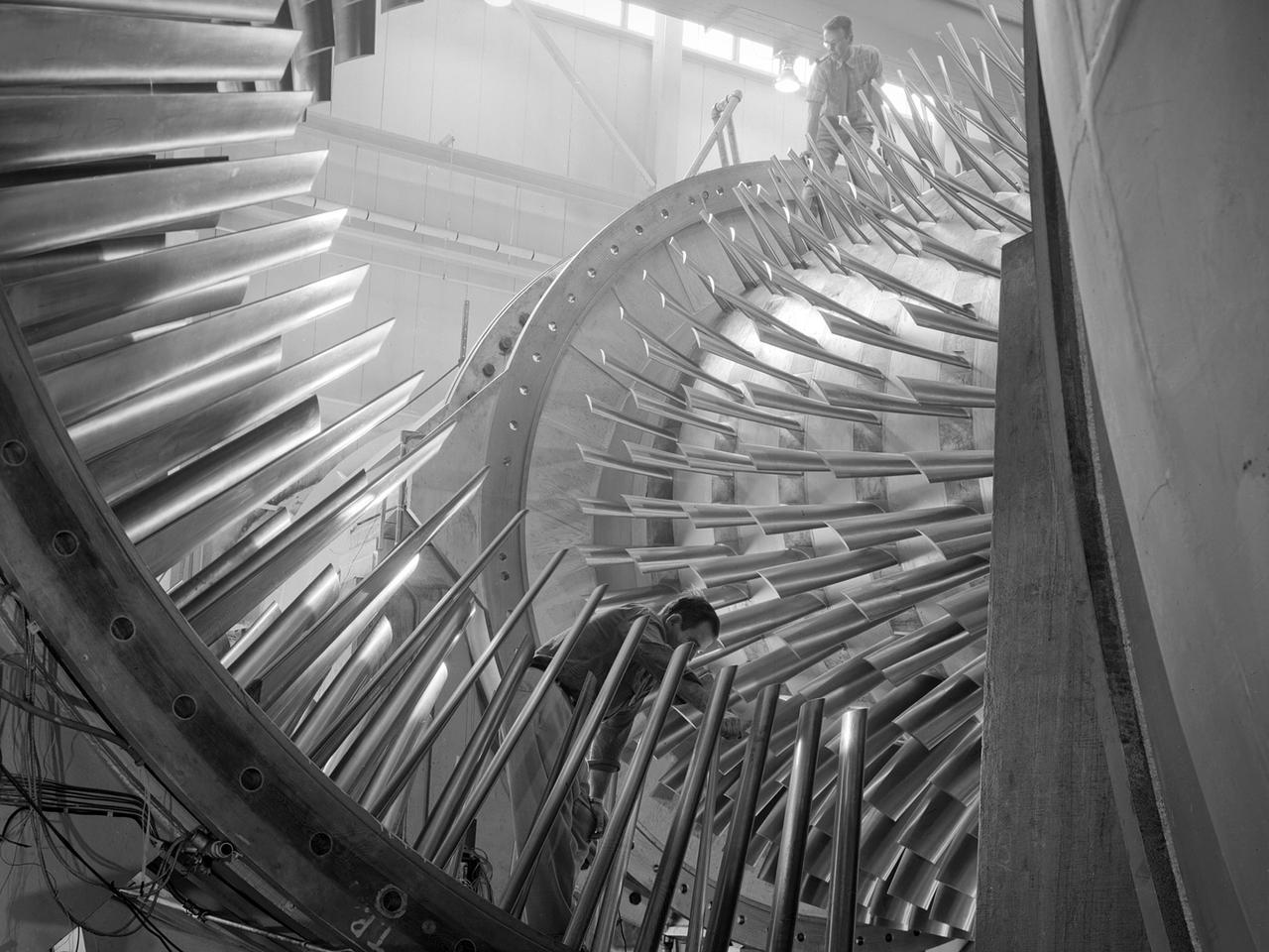 An apprentice at the National Advisory Committee for Aeronautics (NACA) Lewis Flight Propulsion Laboratory shown training on the altitude supply air systems in the Engine Research Building. An ongoing four-year apprentice program was established at the laboratory in 1949 to facilitate the close interaction of the lab’s engineers, mechanics, technicians, and scientists. The apprentice school covered a variety of trades including aircraft mechanic, electronics instrumentation, machinist, and altitude systems mechanic, seen in this photograph.     The apprentices rotated through the various shops and facilities to provide them with a well-rounded understanding of the work at the lab. The specialized skills required meant that NACA apprentices were held to a higher standard than those in industry. They had to pass written civil service exams before entering the program. Previous experience with mechanical model airplanes, radio transmission, six months of work experience, or one year of trade school was required. The Lewis program was certified by both the Department of Labor and the State of Ohio.    One hundred fifty of the 2,000 hours of annual training were spent in the classroom. The remainder was devoted to study of models and hands-on work in the facilities. Examinations were coupled with evaluation by supervisors in the shops. The apprentices were promoted through a series of grades until they reached journeyman status. Those who excelled in the Apprentice Program would be considered for a separate five-year engineering draftsman program.
