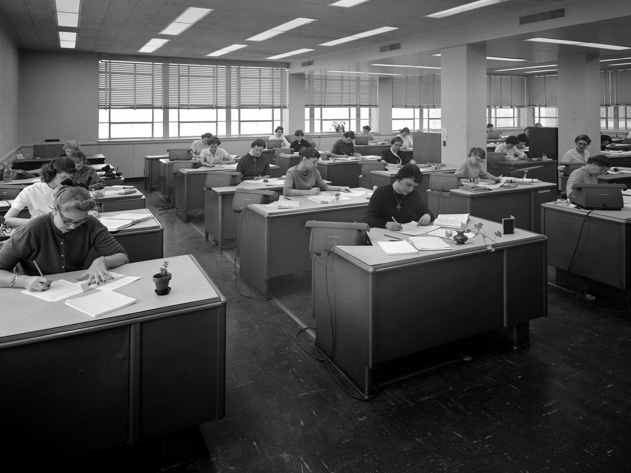 The staff of female computers at work in the 8- by 6-Foot Supersonic Wind Tunnel at the National Advisory Committee for Aeronautics (NACA) Lewis Flight Propulsion Laboratory. The lab’s Computer Section occupied three offices on the second story of the office building at the 8- by 6 facility. The largest office, seen in this photograph, contained approximately 35 women with advanced mathematical skills, a second office housed 20 to 25, and a third 10.   Each major test facility at the laboratory had banks of mercury-filled manometer boards which measured pressure levels at various locations inside the facility’s test section. Often, one board consisting of 100 tubes produced a single data point. There could be scores of data points for each test run. Cameras were set up in front of the manometer boards to capture the readings throughout the test.     The following day the computers, seen in this photograph, would receive the photographs and plot the data points on a graph. The process often took days. It might be weeks before the researchers received the results of their tests. The Friden adding machines can be seen on some of the desks.