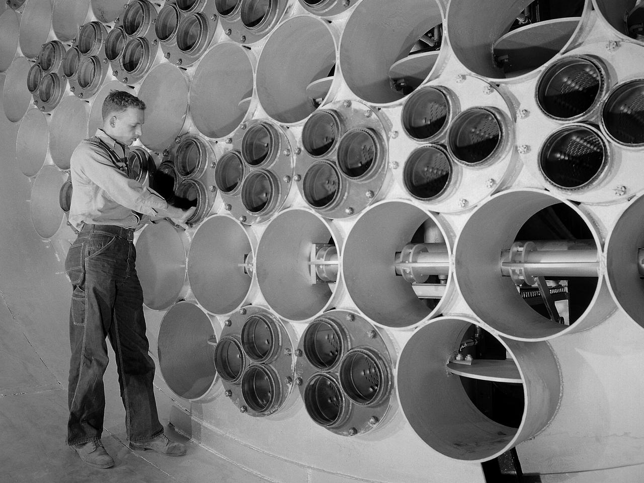 The 10- by 10-Foot Supersonic Wind Tunnel at the NACA Lewis Flight Propulsion Laboratory was built under the Congressional Unitary Plan Act which coordinated wind tunnel construction at the NACA, Air Force, industry, and universities. The 10- by 10, which began operation in 1956, was the largest of the three NACA tunnels built under the act.      Researchers could test engines up to five feet in diameter in the 10- by 10-foot test section. A 250,000-horsepower axial-flow compressor fan can generate airflows up to Mach 3.5 through the test section. The incoming air must be dehumidified and cooled so that the proper conditions are present for the test. A large air dryer with 1,890 tons of activated alumina soaks up 1.5 tons of water per minute from the airflow. A cooling apparatus equivalent to 250,000 household air conditioners is used to cool the air.    The air heater is located just upstream from the test section. Natural gas is combusted in the tunnel to increase the air temperature. The system could only be employed when the tunnel was run in its closed-circuit propulsion mode.