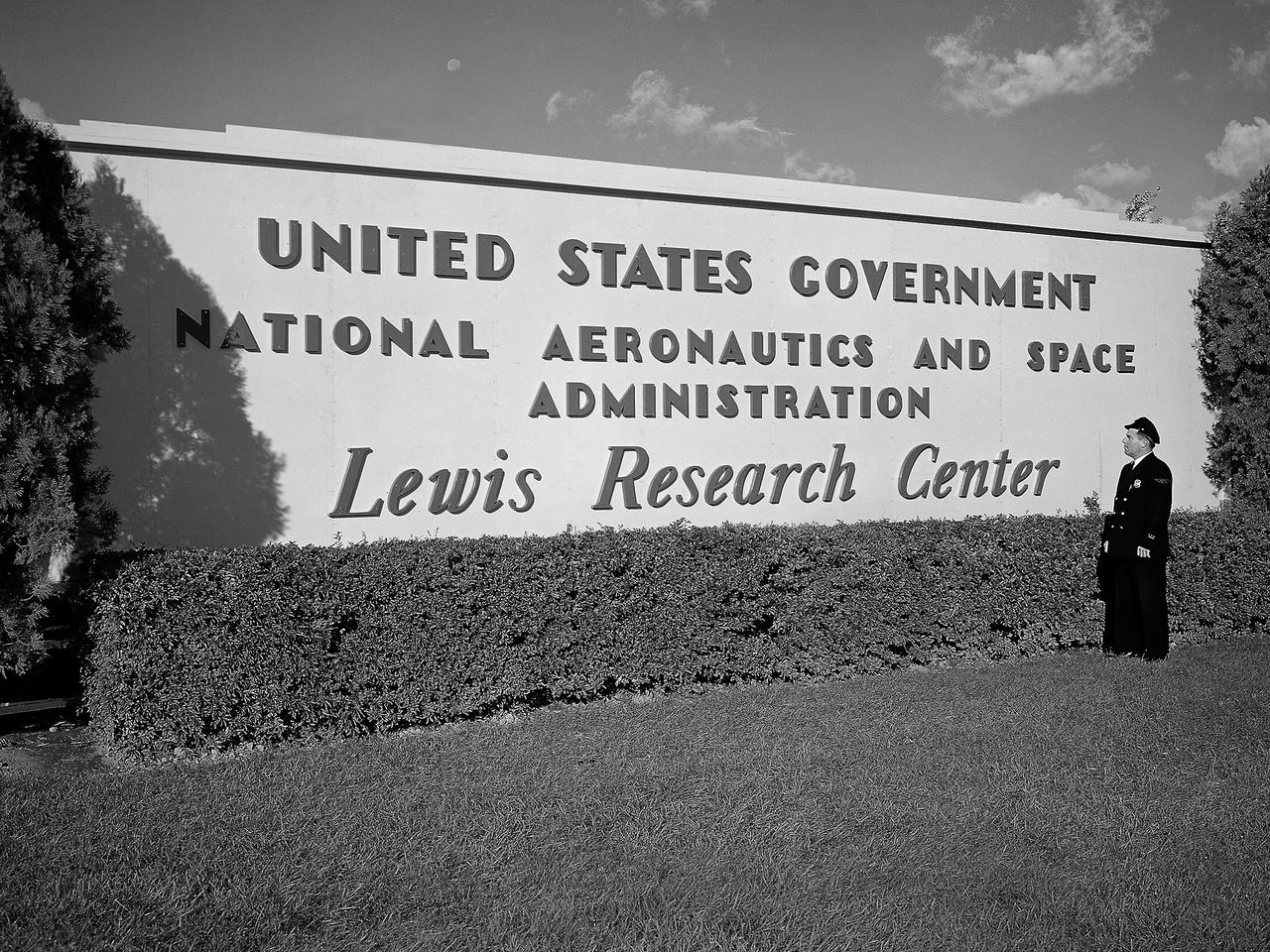 A security guard examines the new sign near the entrance to the Lewis Research Center one day after the National Aeronautics and Space Administration (NASA) was officially established. NASA came into being on October 1, 1958, and the National Advisory Committee for Aeronautics (NACA) Lewis Flight Propulsion Laboratory became the NASA Lewis Research Center. Lewis underwent a major reorganization and began concentrating its efforts almost exclusively on the space program. NACA Lewis researchers had been advocating further space research for years. As early as 1955, Lewis management urged the NACA expand its rocket engine research as a logical extension of its aircraft engine work. Lewis management claimed that space exploration was imperative for the nation’s survival during the Cold War. They called for an annual 25-percent increase in the NACA’s staff, a new space laboratory, a launching center, communications center, and other facilities. They were basically outlining what would be needed for the new space agency. During NASA’s first two years of existence, Lewis refocused its efforts almost completely on the space program. Less than 10 percent of the annual budget was dedicated to aeronautics. In the aftermath that followed President Kennedy’s April 1961 “Urgent Needs” address to Congress, NASA was given a seemingly unlimited budget. The Agency reorganized and began swelling its ranks through a massive recruiting effort to accomplish the accelerated lunar landing mission. Lewis personnel increased from approximately 2,700 in 1961 to over 4,800 in 1966.