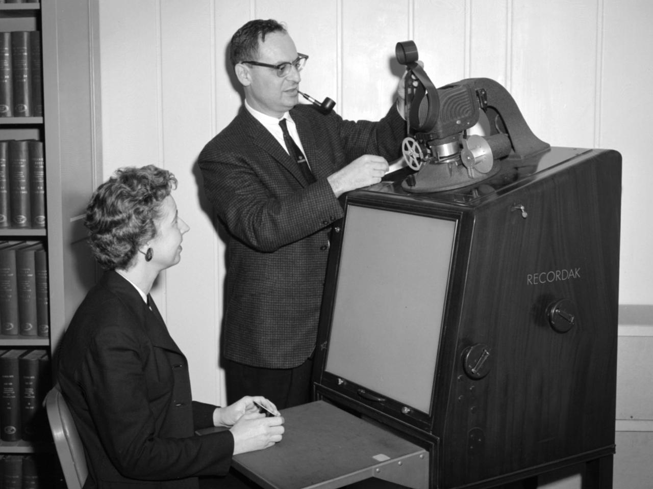 Jean Neidengard and George Mandel operate a Kodak Recordak microfilm reader in the library at the National Aeronautics and Space Administration (NASA) Lewis Research Center. The library was located in the Administration Building until the mid-1960s. It was then moved to the Propulsion Systems Laboratory Office Building. In 2008 the library was moved once again, to the Research Analysis Center. At the time of this photograph, the Lewis library claimed to possess “One of the most complete aero-technical collections in the world.” It was doing a brisk business in the early 1960s. During 1960 alone the library acquired 19,000 new documents and provided 100,000 documents to customers. The library’s eleven-person staff provided reference services, archived technical reports, and supplied periodicals. The staff also included Sam Reiss, a full-time translator who could read 30 languages. He translated technical reports from all over the world for the Lewis research staff. Jean Neidengard oversaw the secret Atomic Energy Commission (AEC) documents in the collection. NASA was partnering with the AEC at the time on Nuclear Engine for Rocket Vehicle Application (NERVA) program. NASA Lewis was the agency’s lead center in the NERVA program. Neidengard’s husband Bill was the head mechanic in the Propulsion Systems Laboratory. George Mandel led the library staff from 1955 to 1968.