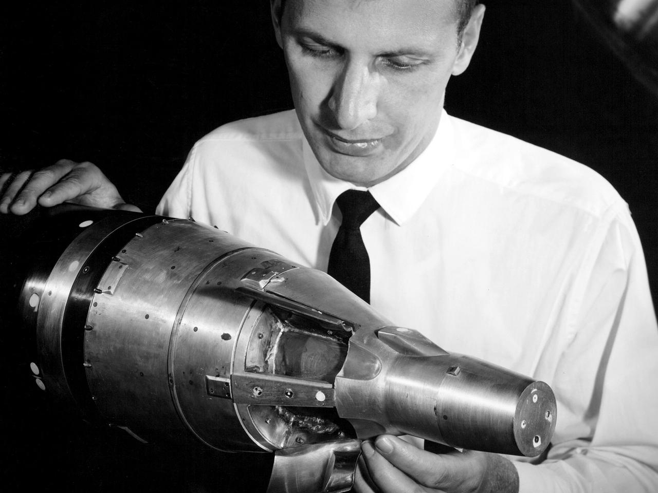 A researcher at the National Aeronautics and Space Administration (NASA) Lewis Research Center examines a small-scale model of the Gemini capsule in the 10- by 10-Foot Supersonic Wind Tunnel test section. Gemini was added to NASA’s manned space program after its predecessor, Mercury, and its antecedent, Apollo, were already established. Gemini was a transitional mission designed provide the astronauts with practice docking with other spacecraft and withstanding durations in space up to two weeks. The program was officially announced on December 7, 1961, but planning began in mid-1959. It was named Gemini after the zodiac twins because of the spacecraft’s two passenger capacity.    The Gemini Program was the first program to start at the new Manned Spacecraft Center in Houston, now the Johnson Space Center. Unlike Mercury and Apollo, Lewis had very little involvement with the Gemini Program. This model was tested in the 10- by 10 tunnel for several weeks in September 1962. Lewis began managing the Agena second-stage rocket program shortly after this photograph was taken. Agenas were used to launch a variety of spacecraft and satellites in the 1960s. They were also used on several Gemini missions to provide targets for the astronauts to practice their rendezvous maneuvers.     Gemini had two unmanned and ten manned flights in 1965 and 1966. These yielded the first spacewalks, long-duration space missions, first onboard computer, docking with a second spacecraft, and rendezvous maneuvers.