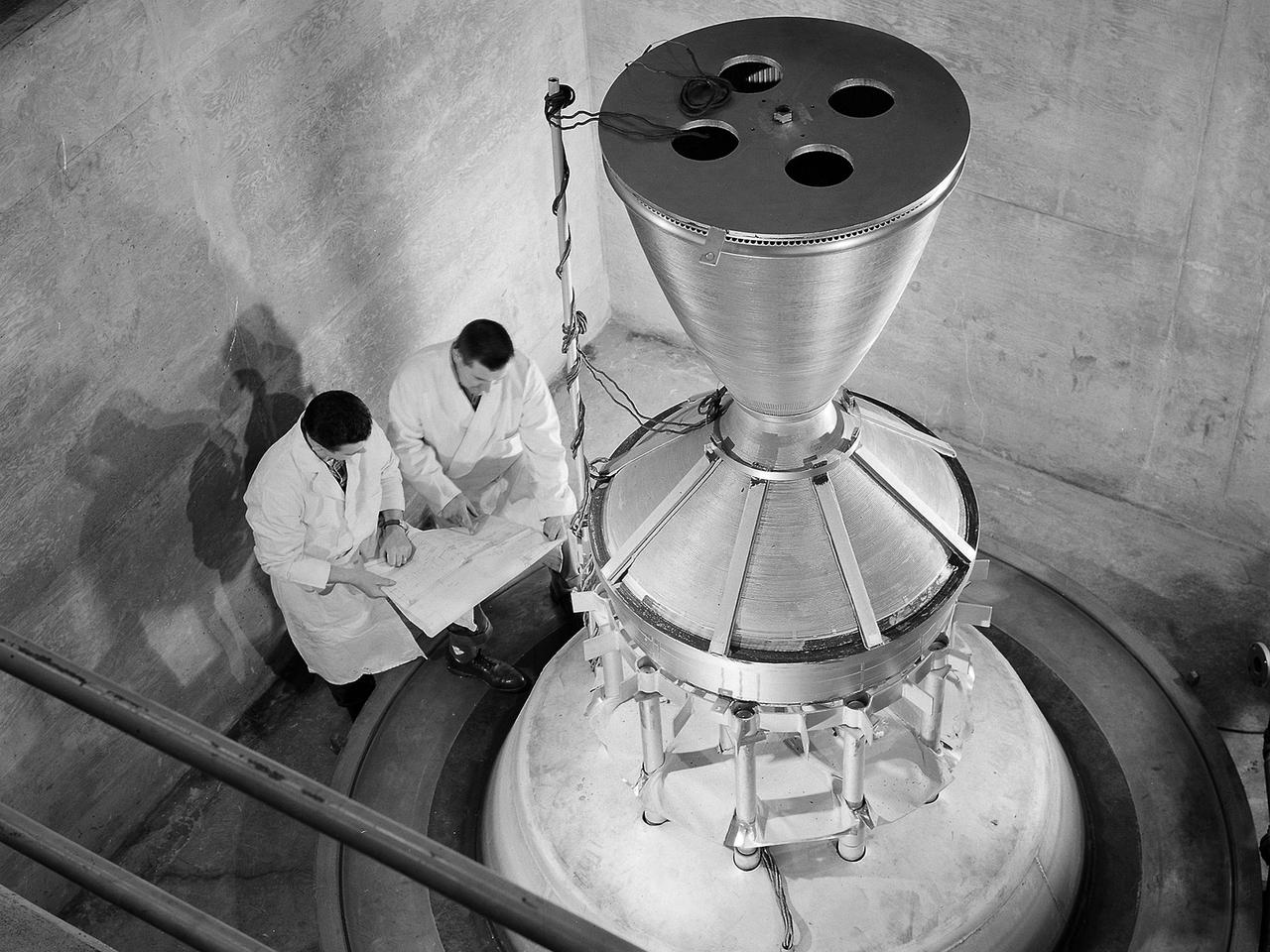 Technicians manufacture a nozzle for the Kiwi B-1-B nuclear rocket engine in the Fabrication Shop’s vacuum oven at the National Aeronautics and Space Administration (NASA) Lewis Research Center. The Nuclear Engine for Rocket Vehicle Applications (NERVA) was a joint NASA and Atomic Energy Commission (AEC) endeavor to develop a nuclear-powered rocket for both long-range missions to Mars and as a possible upper-stage for the Apollo Program. The early portion of the program consisted of basic reactor and fuel system research. This was followed by a series of Kiwi reactors built to test basic nuclear rocket principles in a non-flying nuclear engine. The next phase, NERVA, would create an entire flyable engine. The final phase of the program, called Reactor-In-Flight-Test, would be an actual launch test.    The AEC was responsible for designing the nuclear reactor and overall engine. NASA Lewis was responsible for developing the liquid-hydrogen fuel system. The turbopump, which pumped the fuels from the storage tanks to the engine, was the primary tool for restarting the engine. The NERVA had to be able to restart in space on its own using a safe preprogrammed startup system. Lewis researchers endeavored to design and test this system.     This non-nuclear Kiwi engine, seen here, was being prepared for tests at Lewis’ High Energy Rocket Engine Research Facility (B-1) located at Plum Brook Station. The tests were designed to start an unfueled Kiwi B-1-B reactor and its Aerojet Mark IX turbopump without any external power.