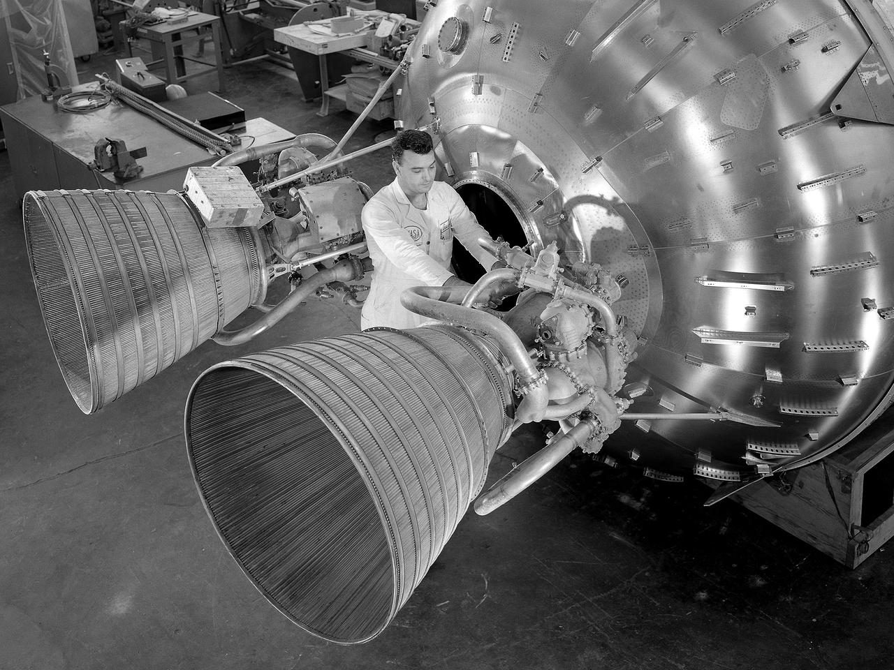 A researcher prepares a Centaur 6A second-stage rocket for a series of tests in the Space Power Chambers’ vacuum tank at the National Aeronautics and Space Administration (NASA) Lewis Research Center. Lewis was assigned oversight of the Centaur Program in the fall of 1962. Prior to that, Centaur’s only launch had failed shortly after liftoff. Lewis engineers undertook an expansive effort to quickly resolve Centaur’s problems and prepare it for its planned missions to send Surveyor spacecraft to land on the moon.    For one test program, a complete Centaur vehicle was lowered into the vacuum chamber at the Space Power Chambers to verify that its electronics and electrical systems functioned reliably in a space environment. At the time, electronic malfunctions were one of the most likely causes of failures in space. Studying these systems during long soaks inside the space tank helped the Lewis team calibrate them and facilitate the monitoring of the spacecraft during an actual flight.    The Centaur for the tests was delivered to Cleveland in a C-130 aircraft on September 27, 1963. The rocket was set up in the facility’s high bay where Lewis technicians and General Dynamics consultants updated its flight systems to match the upcoming Atlas-Centaur-4 mission, as seen in this photograph.
