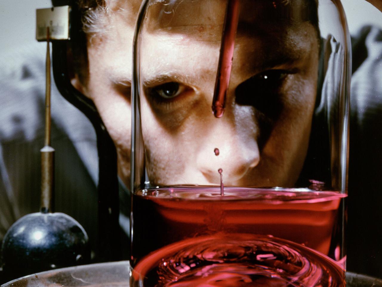 A researcher fills a small container used to represent a liquid hydrogen tank in preparation for a microgravity test in the 2.2-Second Drop Tower at the National Aeronautics and Space Administration (NASA) Lewis Research Center. For over a decade, NASA Lewis endeavored to make liquid hydrogen a viable propellant. Hydrogen’s light weight and high energy made it very appealing for rocket propulsion.     One of the unknowns at the time was the behavior of fluids in the microgravity of space. Rocket designers needed to know where the propellant would be inside the fuel tank in order to pump it to the engine. NASA Lewis utilized sounding rockets, research aircraft, and the 2.2 Second Drop Tower to study liquids in microgravity. The drop tower, originally built as a fuel distillation tower in 1948, descended into a steep ravine. By early 1961 the facility was converted into an eight-floor, 100-foot tower connected to a shop and laboratory space. Small glass tanks, like this one, were installed in experiment carts with cameras to film the liquid’s behavior during freefall.    Thousands of drop tower tests in the early 1960s provided an increased understanding of low-gravity processes and phenomena. The tower only afforded a relatively short experiment time but was sufficient enough that the research could be expanded upon using longer duration freefalls on sounding rockets or aircraft. The results of the early experimental fluid studies verified predictions made by Lewis researchers that the total surface energy would be minimized in microgravity.