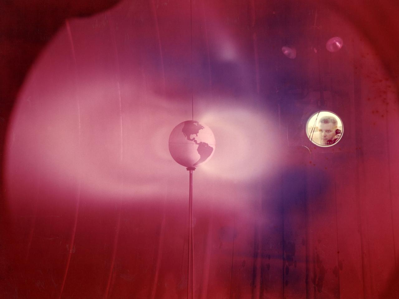 The model of the Earth housed inside Vacuum Tank 5 contained a coil which produced a magnetic field simulating that of the Earth. It was bombarded with a stream of ionized particles simulating the solar wind which impinges on the Earth's magnetic field. The bands or belts of luminous plasma seen in this image were suggestive of the Van Allen belts found around the Earth. Scientists at Lewis probed the plasma around the model and studied scaling laws in an attempt to find an explanation for the actual formation of the Van Allen belt.