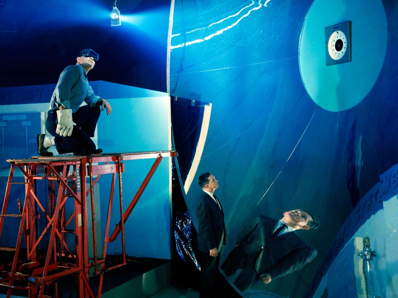 NASA’s Lewis Research Center conducted extensive research programs in the 1960s and 1970s to develop systems that provide electrical power in space. One system, the Brayton cycle engine, converted solar thermal energy into electrical power. This system operated on a closed-loop Brayton thermodynamic cycle. The Brayton system relied on this large mirror to collect radiation from the sun. The mirror concentrated the Sun's rays on a heat storage receiver which warmed the Brayton system’s working fluid, a helium-xenon gas mixture. The heated fluid powered the system’s generator which produced power.     In the mid-1960s Lewis researchers constructed this 30-foot diameter prototype of a parabolic solar mirror for the Brayton cycle system. The mirror had to be rigid, impervious to micrometeorite strikes, and lightweight. This mirror was comprised of twelve 1-inch thick magnesium plate sections that were coated with aluminum. The mirror could be compactly broken into its sections for launch.