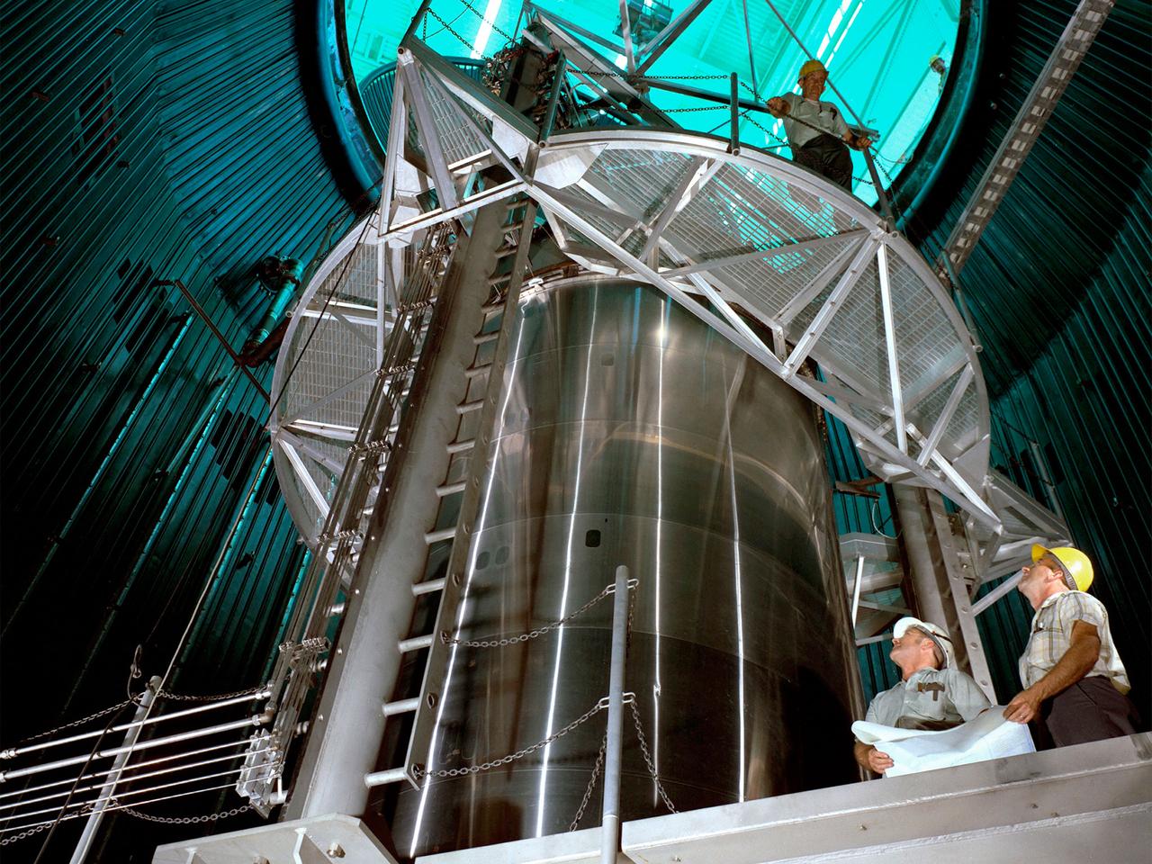 A Centaur second-stage rocket in the Space Propulsion Research Facility, better known as B‒2, operating at NASA’s Plum Brook Station in Sandusky, Ohio. Centaur was designed to be used with an Atlas booster to send the Surveyor spacecraft to the moon in the mid-1960s. After those missions, the rocket was  modified to launch a series of astronomical observation satellites into orbit and send space probes to other planets.     Researchers conducted a series of systems tests at the Plum Brook test stands to improve the Centaur fuel pumping system. Follow up full-scale tests in the B-2 facility led to the eventual removal of the boost pumps from the design. This reduced the system’s complexity and significantly reduced the cost of a Centaur rocket. The Centaur tests were the first use of the new B-2 facility.    B‒2 was the world's only high altitude test facility capable of full-scale rocket engine and launch vehicle system level tests. It was created to test rocket propulsion systems with up to 100,000 pounds of thrust in a simulated space environment. The facility has the unique ability to maintain a vacuum at the rocket’s nozzle while the engine is firing. The rocket fires into a 120-foot deep spray chamber which cools the exhaust before it is ejected outside the facility. B‒2 simulated space using giant diffusion pumps to reduce chamber pressure 10-6 torr, nitrogen-filled cold walls create cryogenic temperatures, and quartz lamps replicate the radiation of the sun.
