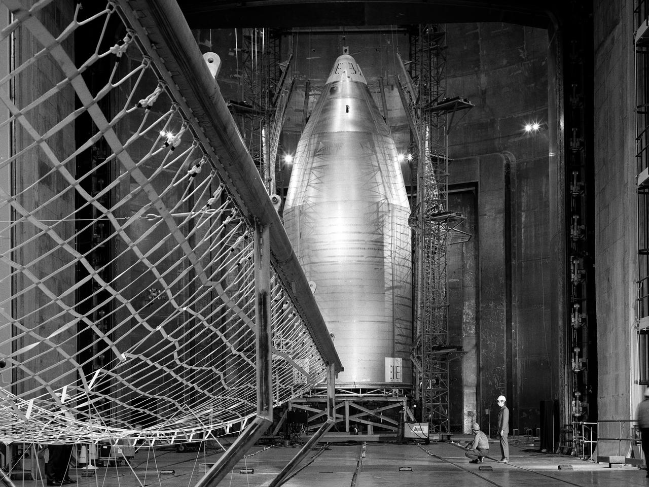 The 56-foot tall, 24,400-pound Skylab shroud installed in the Space Power Facility’s vacuum chamber at the National Aeronautics and Space Administration’s (NASA) Plum Brook Station. The Space Power Facility, which began operations in 1969, is the largest high vacuum chamber ever built. The chamber is 100 feet in diameter and 120 feet high. It can produce a vacuum deep enough to simulate the conditions at 300 miles altitude. The Space Power Facility was originally designed to test nuclear-power sources for spacecraft during long durations in a space atmosphere, but it was never used for that purpose.       Payload shrouds are aerodynamic fairings to protect the payload during launch and ascent to orbit. The Skylab mission utilized the largest shroud ever attempted. Unlike previous launches, the shroud would not be jettisoned until the spacecraft reached orbit. NASA engineers designed these tests to verify the dynamics of the jettison motion in a simulated space environment. Fifty-four runs and three full-scale jettison tests were conducted from mid-September 1970 to June 1971. The shroud behaved as its designers intended, the detonators all fired, and early design issues were remedied by the final test.   The Space Power Facility continues to operate today. The facility can sustain a high vacuum; simulate solar radiation via a 4-megawatt quartz heat lamp array, solar spectrum by a 400-kilowatt arc lamp, and cold environments. Test programs at the facility include high-energy experiments, shroud separation tests, Mars Lander system tests, deployable Solar Sail tests and International Space Station hardware tests.