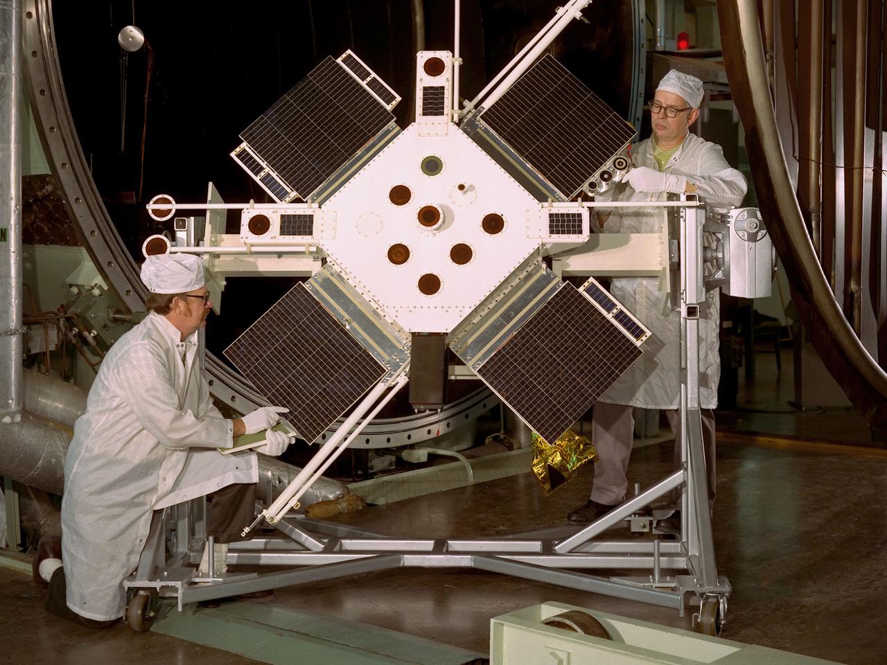 Researchers examine the Space Plasma-High Voltage Interaction Experiment (SPHINX) satellite in the Electric Propulsion Laboratory at the National Aeronautics and Space Administration (NASA) Lewis Research Center. Lewis’ Spacecraft Technology Division designed SPHINX to study the electrical interaction of its experimental surfaces with space plasma. They sought to determine if higher orbits would improve the transmission quality of communications satellites. Robert Lovell, the Project Manager, oversaw vibrational and plasma simulation testing of the satellite in the Electric Propulsion Laboratory, seen here.     SPHINX was an add-on payload for the first Titan/Centaur proof launch in early 1974. Lewis successfully managed the Centaur Program since 1962, but this would be the first Centaur launch with a Titan booster. Since the proof test did not have a scheduled payload, the Lewis-designed SPHINX received a free ride.    The February 11, 1974 launch, however, proved to be one of the Launch Vehicle Division’s lowest days. Twelve minutes after the vehicle departed the launch pad, the booster and Centaur separated as designed, but Centaur’s two RL-10 engines failed to ignite. The launch pad safety officer destroyed the vehicle, and SPHINX never made it into orbit. Overall Centaur has an excellent success rate, but the failed SPHINX launch attempt caused deep disappointment across the center.