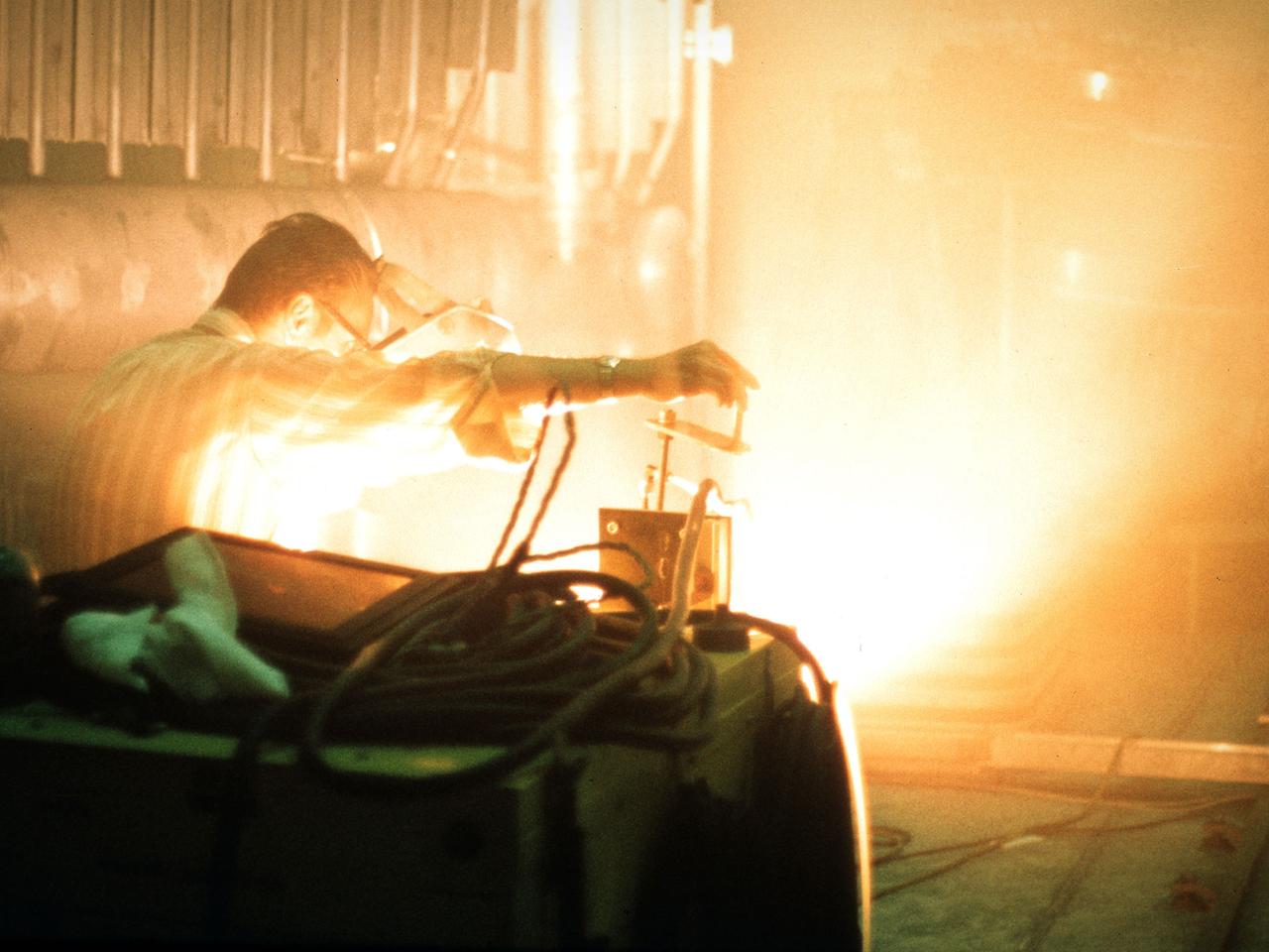 A researcher sets up equipment in the Space Power Chamber at National Aeronautics and Space Administration’s (NASA) Plum Brook Station to study the effects of contaminants on clouds. Drs. Rosa and Jorge Pena of Pennsylvania State University's Department of Meteorology initiated the program in an effort to develop methods of creating stable, long-lasting clouds in a test chamber in order to study their composition and formation. The researchers then wanted to use the artificially-created clouds to determine how they were affected by pollution.    The 100-foot diameter and 122-foot high Space Power Chamber is the largest vacuum chamber in the world. The researchers covered the circular walls with muslin. A recirculating water system saturated the cloth. The facility engineers then reduced the chamber’s pressure which released the water from the muslin and generated a cloud.    The researchers produced five different clouds in this first portion of this study. They discovered that they could not create stable clouds because of the heat generated by the water-pumping equipment. Nonetheless, they felt confident enough to commence planning the second phase of the program using a heat exchanger to cool the equipment.