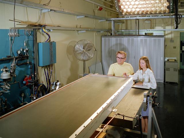 NASA image: Researcher and Mechanic with Solar Collector in Solar Simulator Cell