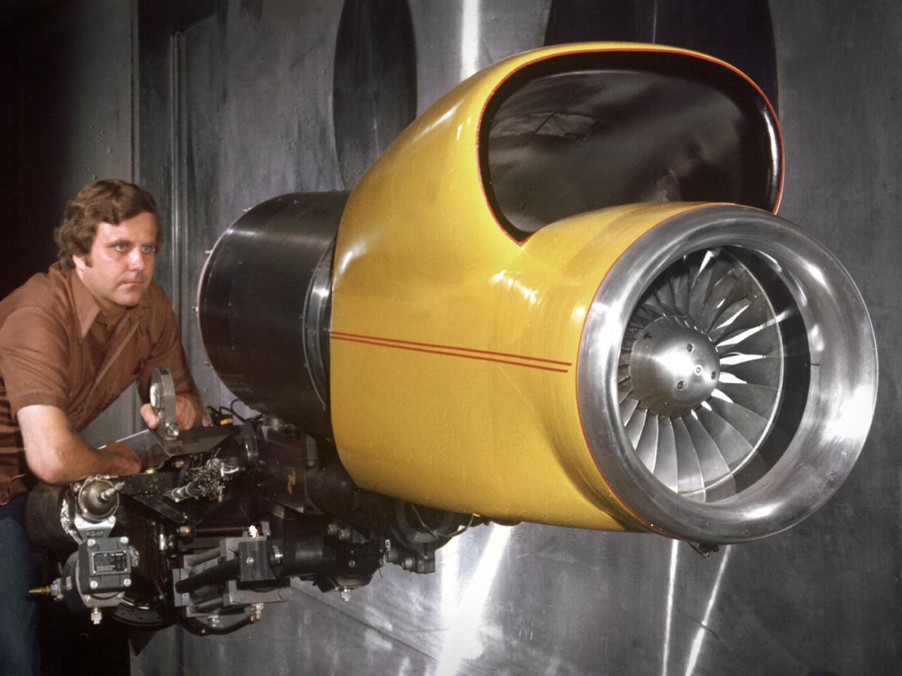 A technician checks a 0.25-scale engine model of a Vought Corporation V-530 engine in the test section of the 10- by 10-Foot Supersonic Wind Tunnel at the National Aeronautics and Space Administration (NASA) Lewis Research Center. Vought created a low-drag tandem-fan Vertical/Short and Takeoff and Landing (V/STOL) engine in the mid-1970s, designated as the V-530. The first fan on the tandem-fan engine was supplied with air through a traditional subsonic inlet, seen on the lower front of the engine. The air was exhausted through the nacelle during normal flight and directed down during takeoffs. The rear fan was supplied by the oval-shaped top inlet during all phases of the flight. The second fan exhausted its air through a rear vectorable nozzle.     NASA Lewis and Vought partnered in the late 1970s to collect an array of inlet and nozzle design information on the tandem fan engines for the Navy. Vought created this .25-scale model of the V-530 for extensive testing in Lewis' 10- by 10-foot tunnel.     During an early series of tests, the front fan was covered, and a turbofan simulator was used to supply air to the rear fan. The researchers then analyzed the performance of only the front fan inlet. During the final series of tests, the flow from the front fan was used to supply airflow to the rear fan. The researchers studied the inlet's recovery, distortion, and angle-of-attack limits over various flight conditions.