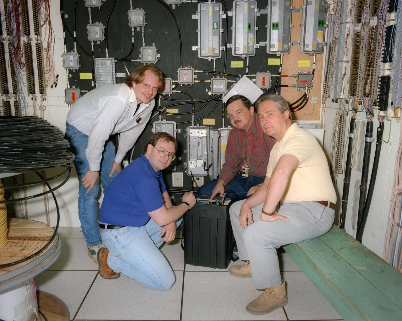 Pictured is the Communications room in the RAC building, Research Analysis Center.  This is the hub for the CATV and Lynk system and also the telephone system as seen from the twisted pair wires.  The test gear LAN 450 is on the floor and is a spectrum analyzer made specifically for CATV.  The Large boxes on the wall are Trunk amps and the smaller boxes are Splitters or combiners.