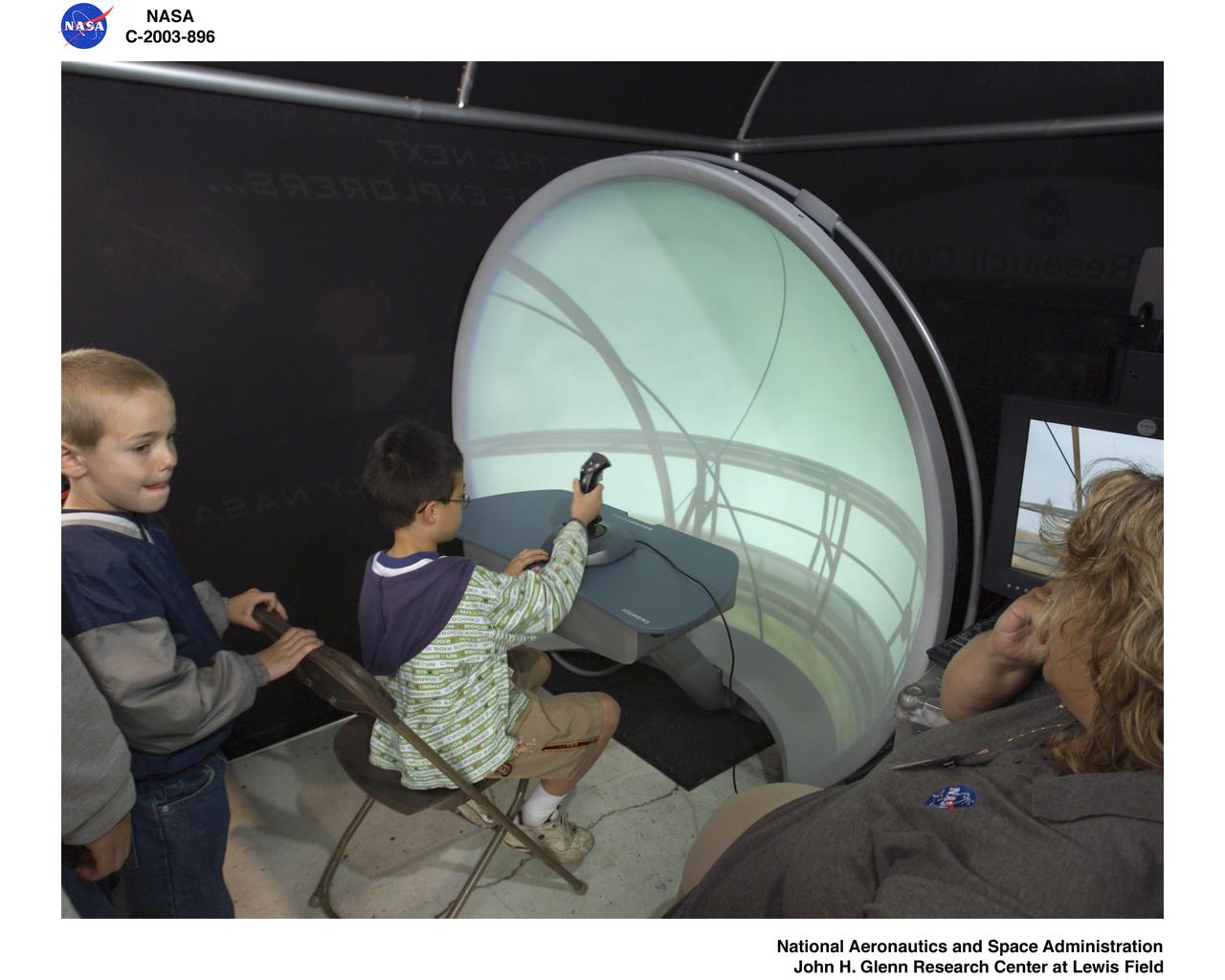FLYING LESSONS - ASSISTANCE BEING GIVEN TO NEXT GENERATION PILOTS IN THE VISIONSTATION AT THE WRIGHT PATTERSON AIR FORCE BASE OPEN HOUSE - AIR POWER 2003, MAY 10-11, 2003