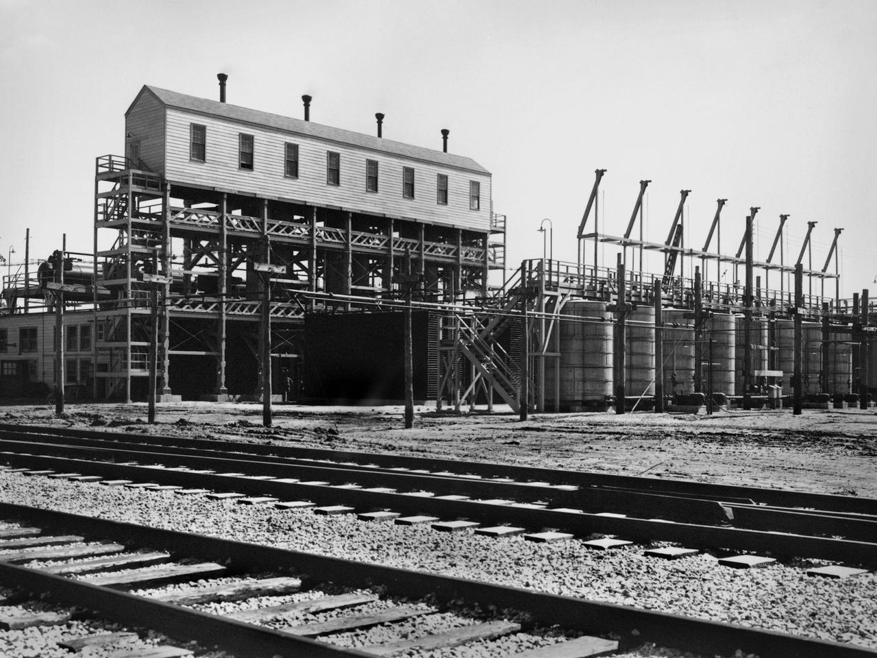 An ammonia oxidation plant at the Plum Brook Ordnance Works near Sandusky, Ohio, which later became the National Aeronautics and Space Administration’s (NASA) Plum Brook Station. During World War II the ordnance works produced trinitroluene (TNT), dinitrotoluene (DNT), and pentolite which were crated and shipped to an arsenal in Ravenna, Ohio. There, the explosives were packed into shells and sent to Allied forces overseas. Plum Brook was the third largest producer of TNT during World War II.     Toluene, sulfuric acid, and nitric acid were used to manufacture the TNT. Nitric Acid is made by oxidizing ammonia, adding water, and concentrating it. The facility in this photograph was used for this oxidation. The structure included air compressors, filters, aftercoolers, power recovery systems, air receivers, heaters, ammonia gasifiers, gas mixers, cooler condensers, absorption columns, and bleaching columns.    The Plum Brook Ordnance Works was shut down immediately after the war and remained vacant for the next ten years. NASA’s predecessor, the National Advisory Committee for Aeronautics (NACA), acquired the 500 acres of the site in 1955 to build a nuclear test reactor. By 1963, the agency had acquired the entire 9000 acres from the Army. Almost all of the military facilities were removed in the early 1960s. Plum Brook Station contained over 30 test facilities at its peak in the late 1960s. Today there are four major facilities in operation.