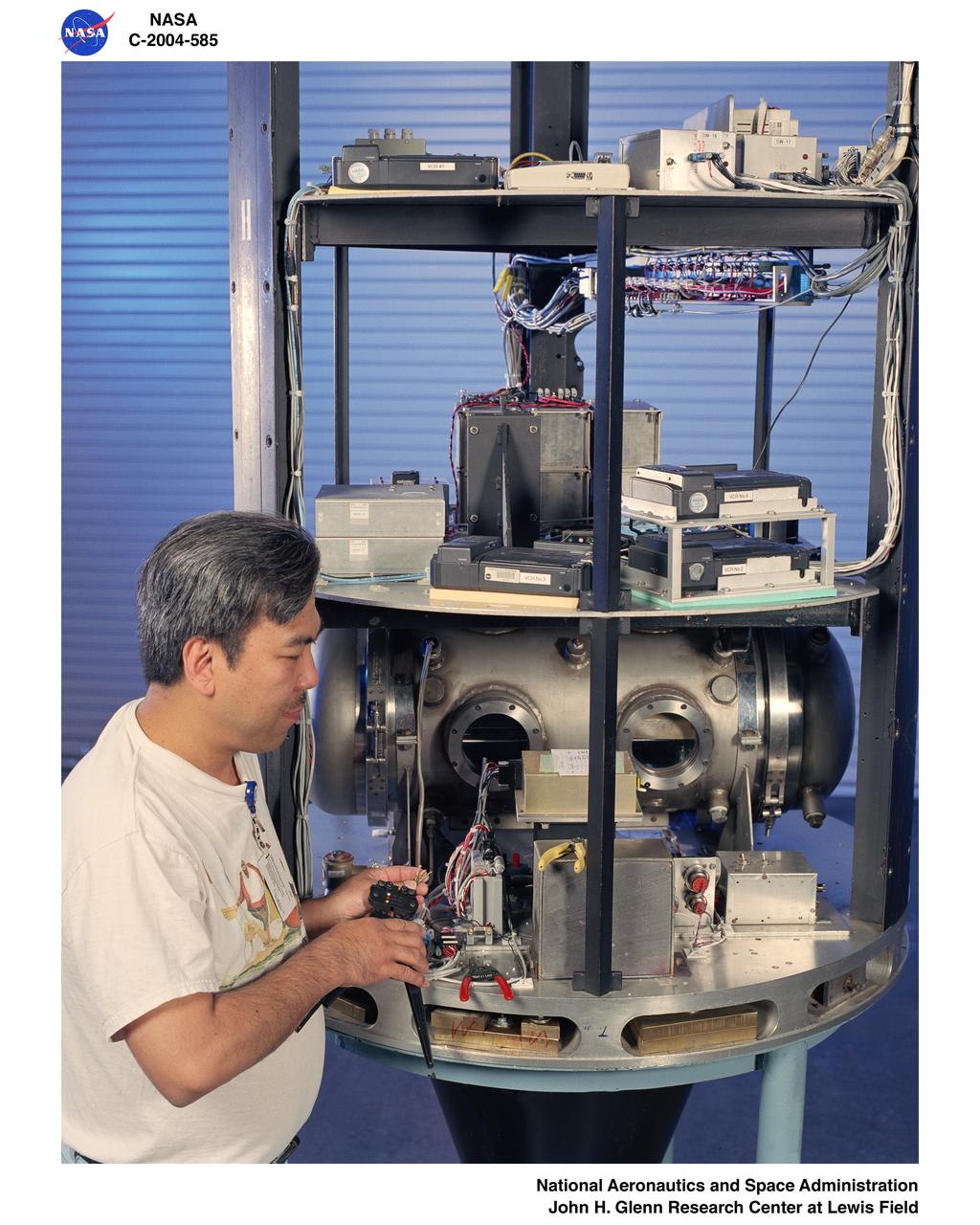An electronics technician makes adjustments to the experiment on the ÒHÓ drop vehicle at the Zero Gravity Research Facility.