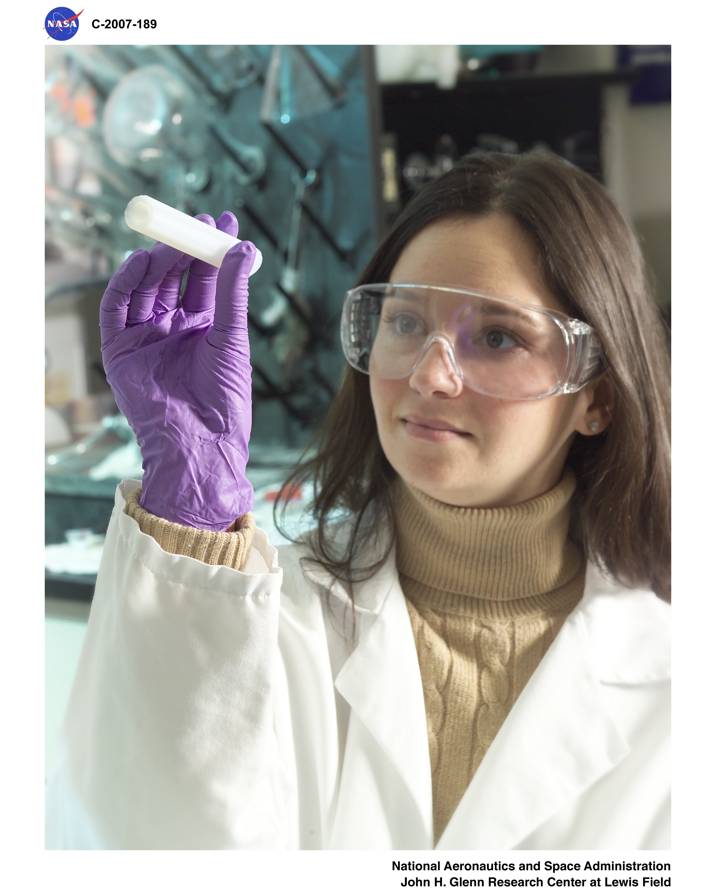 Researcher examines a tubular Aerogel material sample in its "green" state. Aerogels are among the lightest solid materials known to man. They are created by combining a polymer with a solvent to form a gel, and then removing the liquid from the gel and replacing it with air. Aerogels are extremely porous and very low in density. They are solid to the touch. This translucent material is considered one of the finest insulation materials available.
