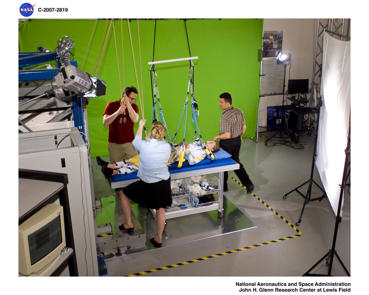 Members of Glen's Exercise Countermeasures Lab work to prepare dancer Sarah Morrison in the Enhanced Zero-gravity Locomotion Simulator for a choreographed video performance entitled "Walking on Other Worlds" produced for IngenuityFest 2007