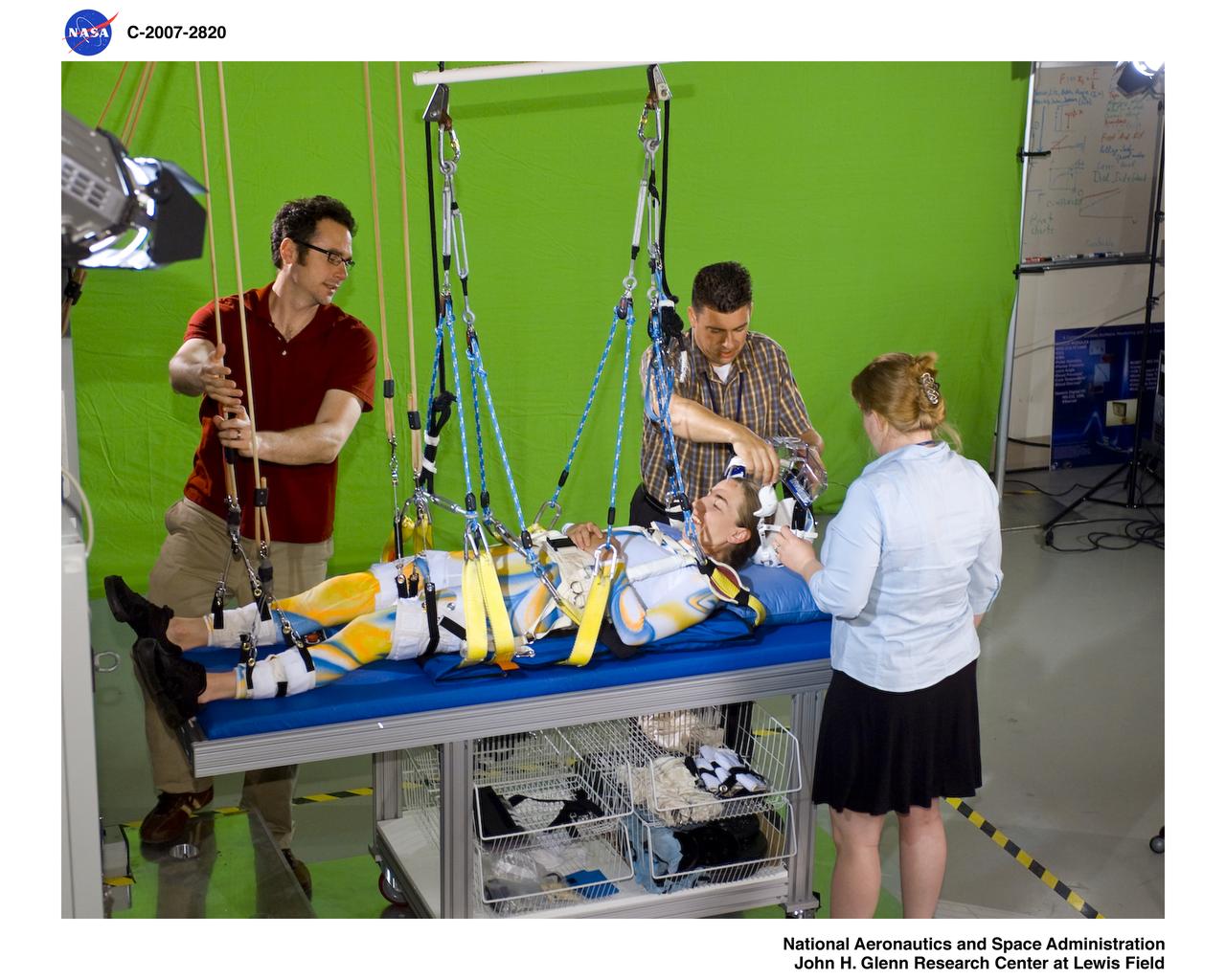 Members of Glen's Exercise Countermeasures Lab work to prepare dancer Sarah Morrison in the Enhanced Zero-gravity Locomotion Simulator for a choreographed video performance entitled "Walking on Other Worlds" produced for IngenuityFest 2007