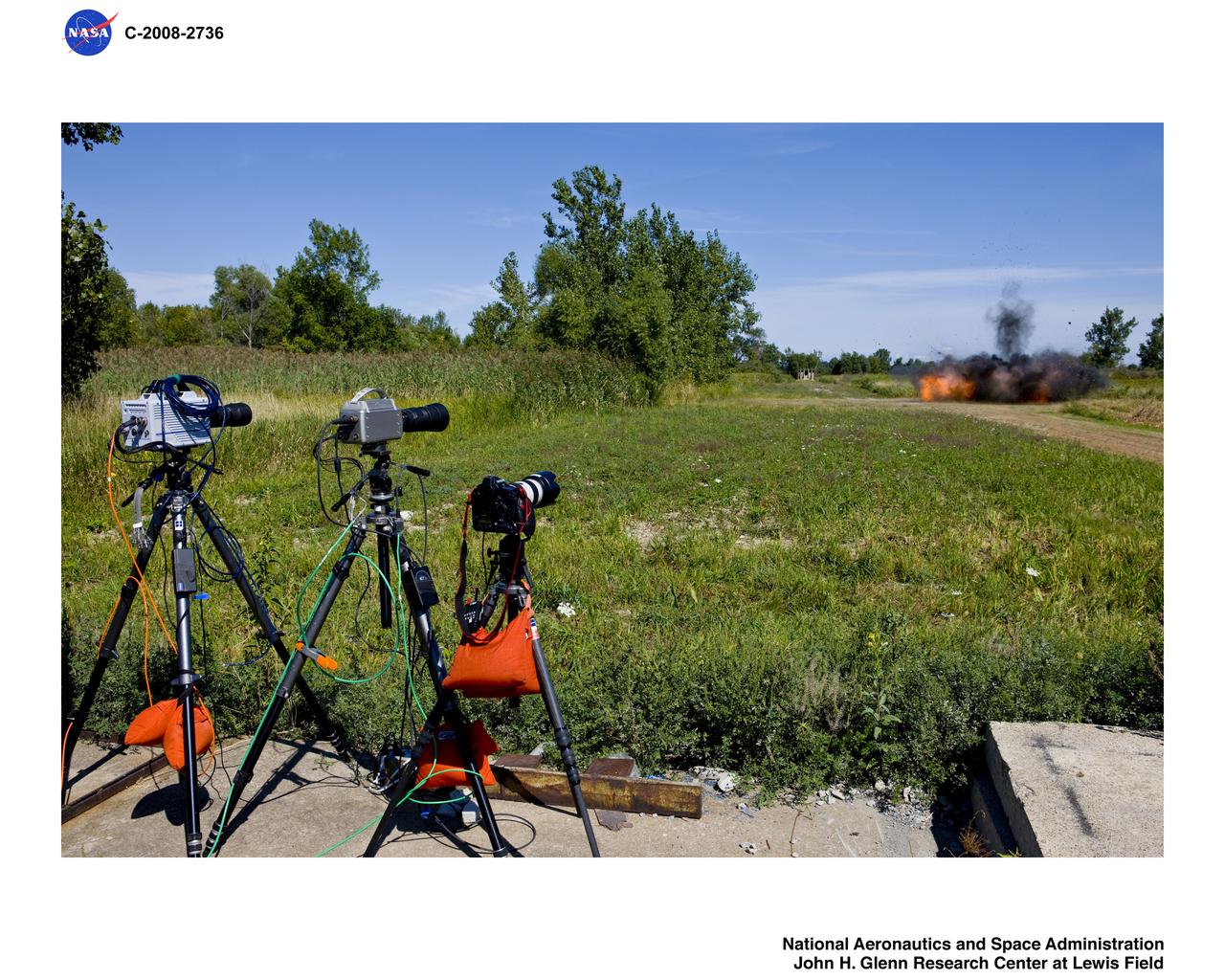 Documentation of explosives detonation at ARES of 10lbs. of C-4 Aerostat Video Program with 2 high speed cameras and digital still camera in foreground