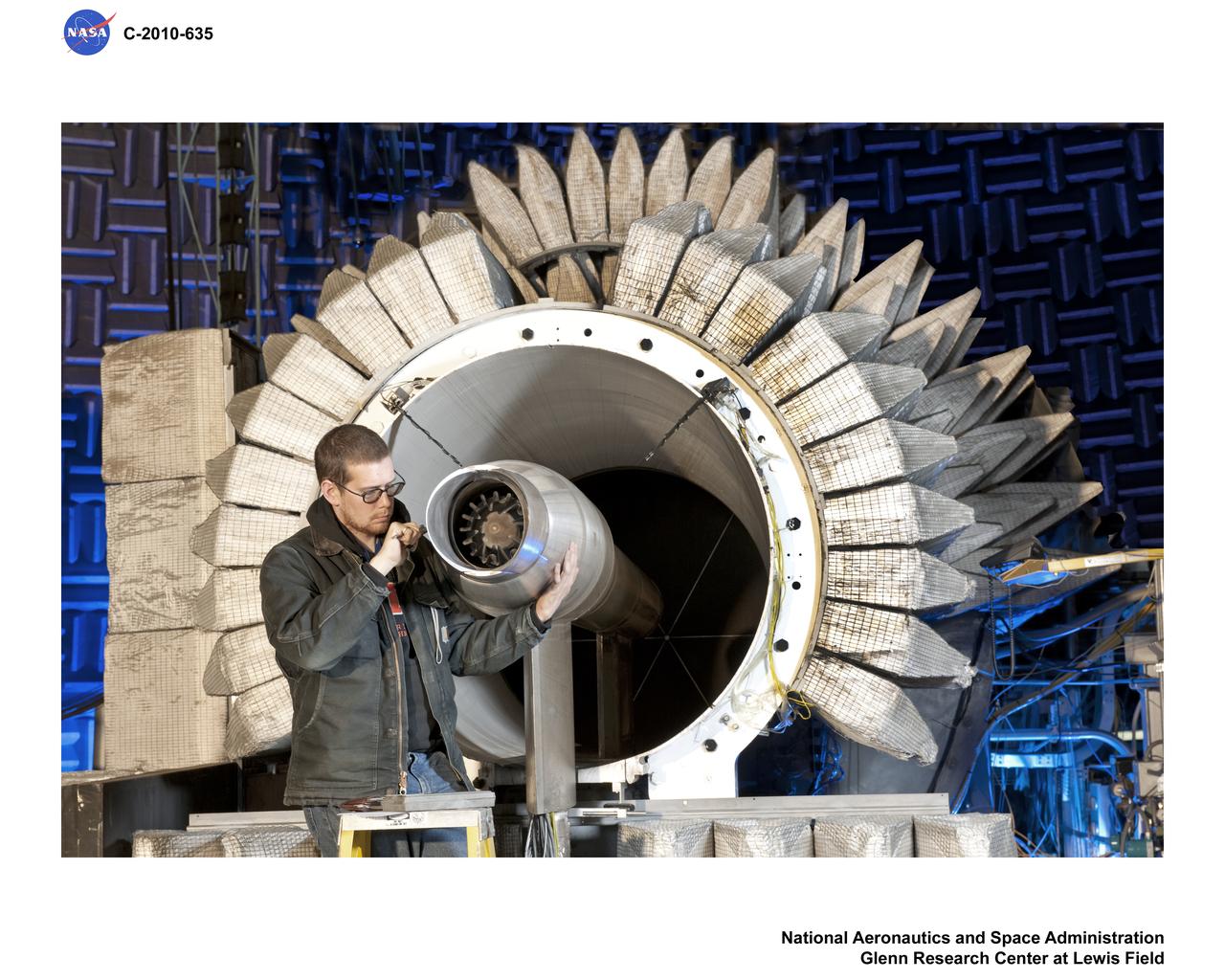 New testing is underway in the Aero-Acoustic Propulsion Laboratory (AAPL) at NASA's Glenn Research Center. The research focuses on a model called the Highly Variable Cycle Exhaust System -- a 0.17 scale model of an exhaust system that will operate at subsonic, transonic and supersonic exhaust speeds in a future supersonic business jet. The model features ejector doors used at different angles. Researchers are investigating the impact of these ejectors on the resulting acoustic radiation. Here, Steven Sedensky, a mechanical engineer with Jacobs Sverdrup, takes measurements of the ejector door positions.
