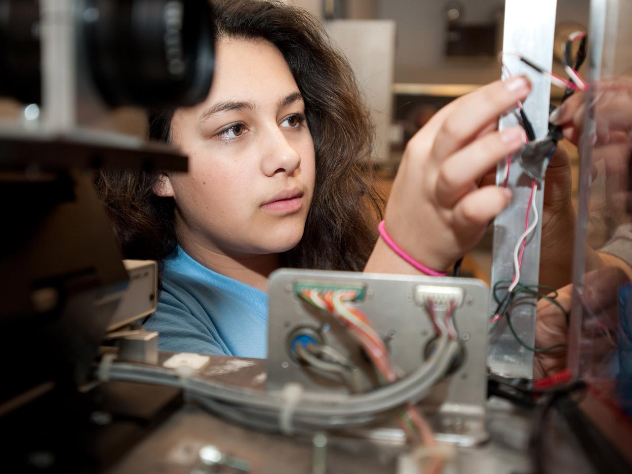 Neera Martin, a NASA Glenn student intern, works on a drop package for the 'Dropping in Microgravity Environment (DIME)' event held in NASA Glenn's 2.2 Second Drop Tower.