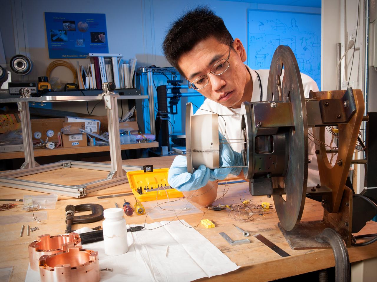 Environmental Portrait of Research Engineer Wensheng Huang working on a Hall thruster in the Electric Propulsion Laboratory at NASA Glenn Research Center.