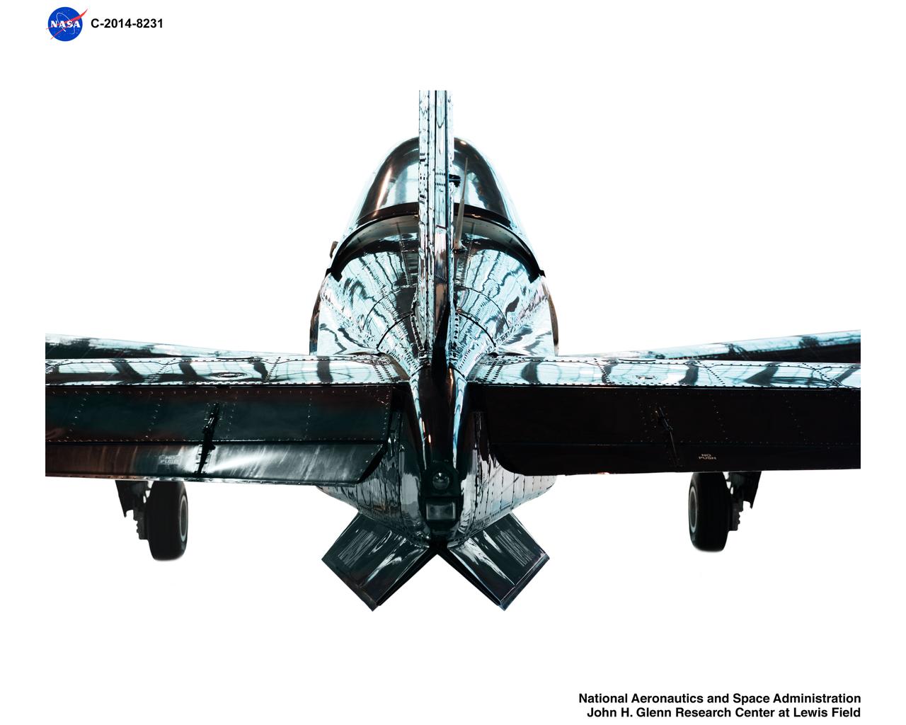 A T34-C aircraft reflects the large multi-paned windows on the Hangar doors.  When NASA GRC obtained this T-34C from the Navy it was painted in ‚Äúthrowback‚Äù paint schemes from an earlier time in celebration of the 100th birthday of Naval Aviation.  NASA kept it in the original paint job for posterity.  This T-34C airplane will be GRCs surrogate aircraft for Unmanned Aircraft Systems in the National Airspace System aeronautics initiative. A T34-C aircraft reflects the large multi-paned windows on the Hangar doors.  When NASA GRC obtained this T-34C from the Navy it was painted in “throwback” paint schemes from an earlier time in celebration of the 100th birthday of Naval Aviation.  NASA kept it in the original paint job for posterity.  This T-34C airplane will be GRCs surrogate aircraft for Unmanned Aircraft Systems in the National Airspace System aeronautics initiative.