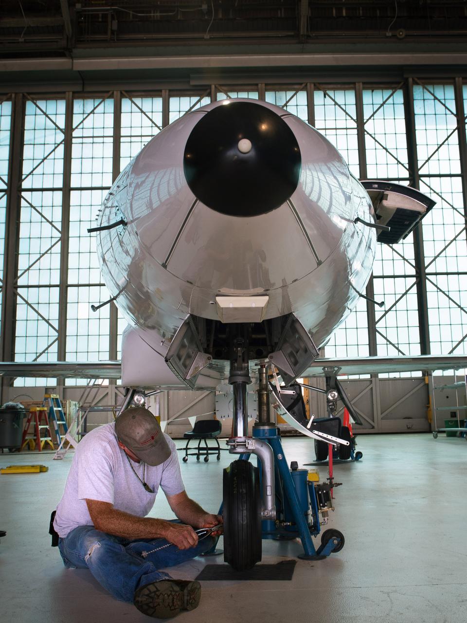 NASA Glenn Mechanic Thomas Thompson checks the nose wheel axle nut on NASA Glenn’s Learjet 25 research aircraft.