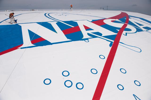 NASA image: Painters paint the NASA Insignia or Meatball on the Hangar Roof