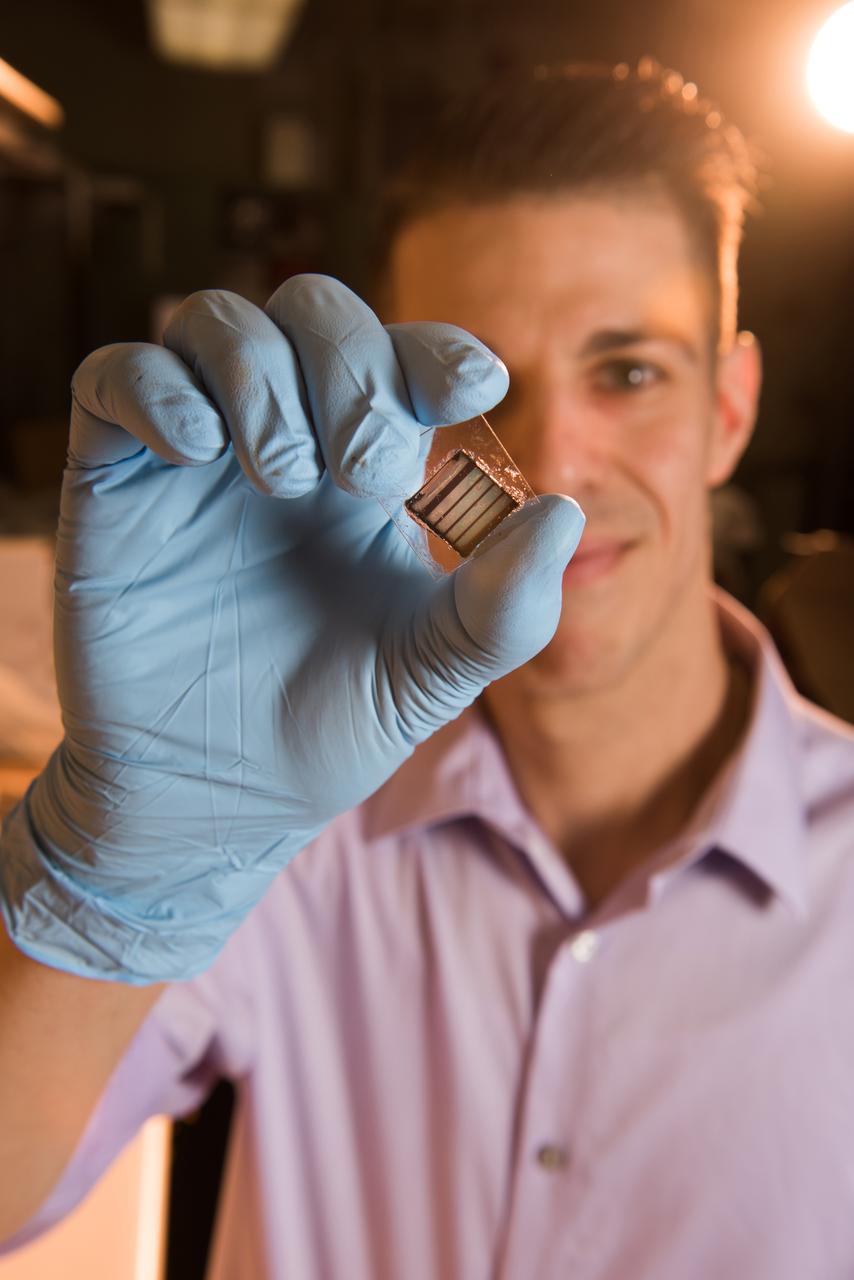 NASA Glenn researcher Tim Peshek shows off a new type of ultrathin solar cell, known as a ‘perovskite’ because of its structure. These solar cells show promise for space applications because of their high efficiency and radiation tolerance and open the door to extremely low cost and large solar arrays for spacecraft or lunar surface habitats.