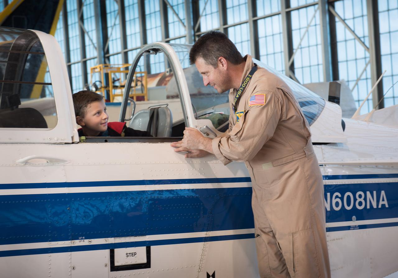 Jeremiah Kawczak checks out the T-34 aircraft with the help of Pilot and Chief of Aircraft Operations, James Demers at the Glenn Research Center Hangar during the NASA 60th Anniversary Public Tours