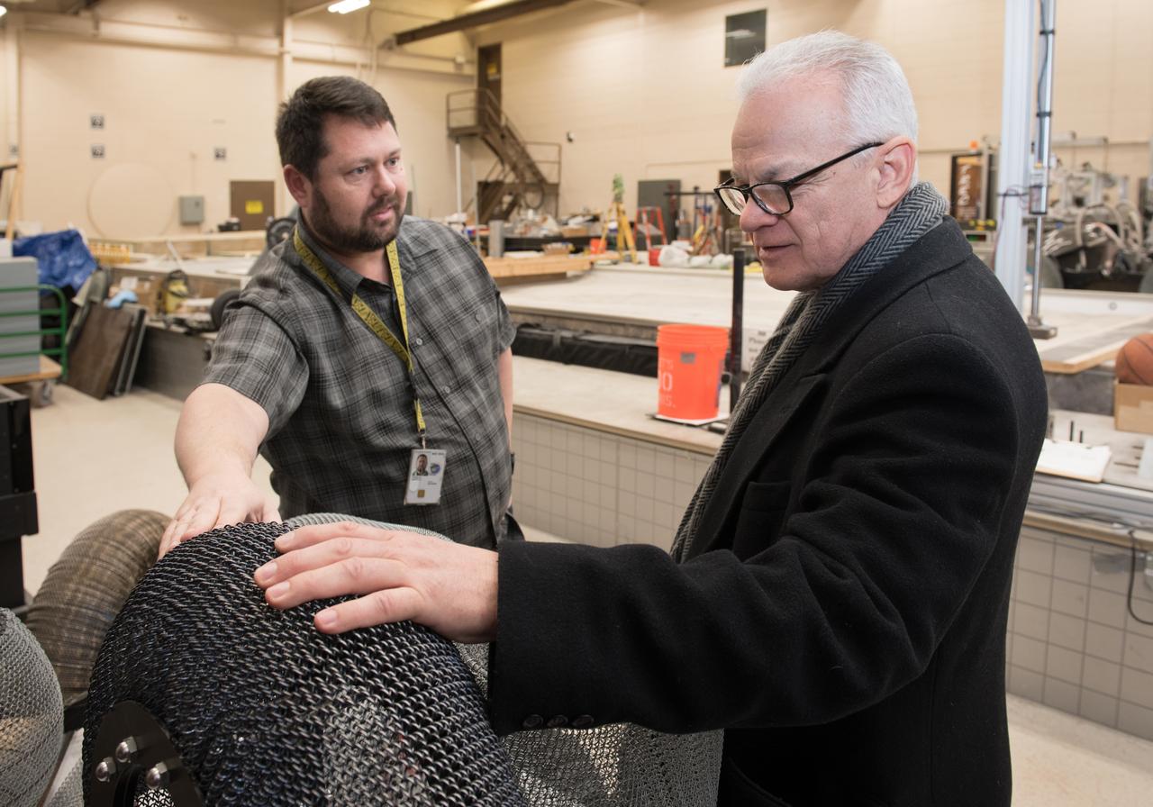 A Co-inventor of the Shape Memory Alloy, Spring Tire, shows the NASA Chief Technologist the first SMA Spring Tire Prototype during a tour of the Glenn Research Center, Simulated Lunar Operations Laboratory (SLOPE).