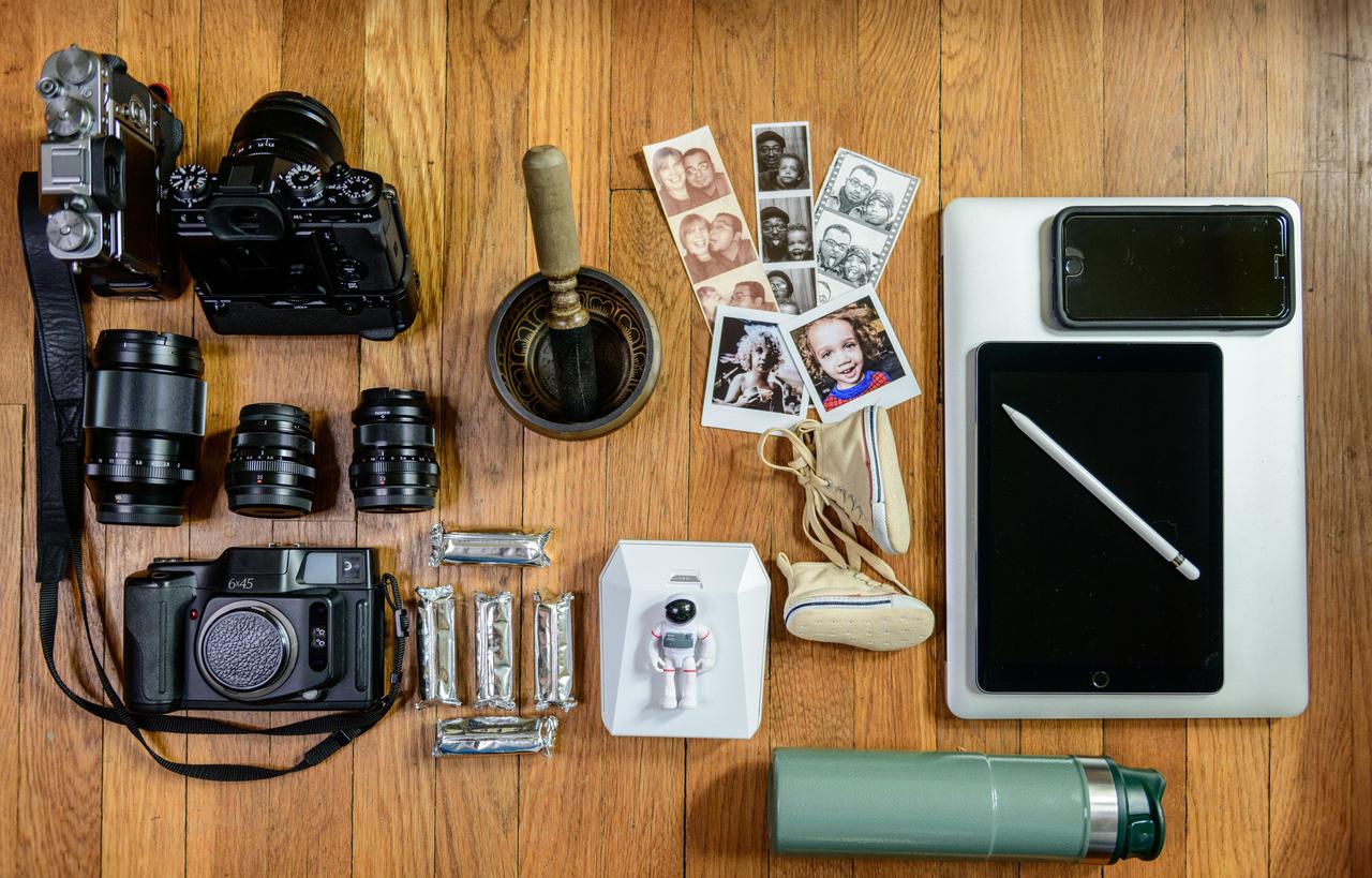 Two mirrirless Digital Camers, 56mm f1.2 lens, 90mm f2 lens, 35mm f2 lens, 23mm f2 lens, 6x4.5 Medium Format Film Camera, 120 film, Singing Bowl, wirerless instant printer, My 3yr olds Astronaut toy, family photos, Oldest Sons (27) baby shoes for luck, Laptop, Phone (for music), Tablet and Pen, Water Bottle.