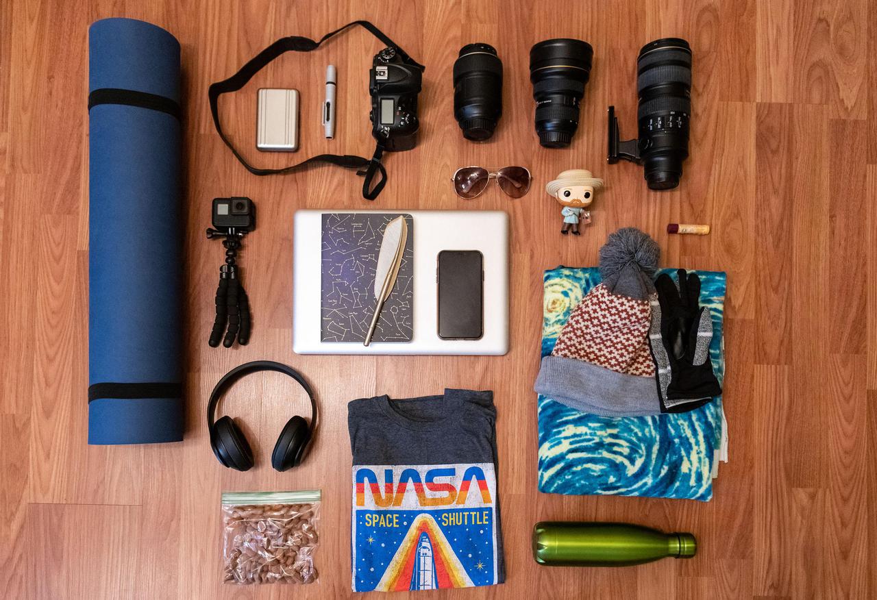 I may not always pack light, but I tried to only pack the essentials, with a couple of goodies.  I get cold fairly easily hence the blanket, extra NASA shirt, hat and gloves.  No trip is complete without my favorite snack of almonds, water, sunglasses, Chapstick, phone and my headphones to listen to some music.  I figured I could bring my yoga mat, because who wouldn’t want to do yoga on the moon??  The most important part of this kit is my camera!  I brought a couple of different lenses for a variety of options, along with a sports action camera, notebook and computer for editing.  The Van Gogh doll was just for fun! 