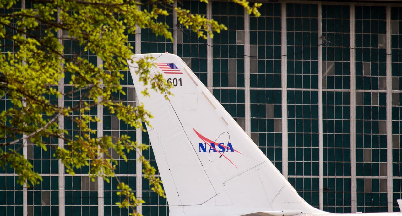 The Lockheed Viking S-3B aircraft was parked for re-fulling out near the hangar at Glenn Research Center in preparation for its departure and retirement from service.  This former NAVY aircraft was the last such aircraft still flying.  It has gone to a museum on the west coast.  After leaving service with the NAVY, it came to GRC to be used in aircraft icing experiments.  Tree branches frame the tail of this old war bird in front of the glass windows of the hangar door.