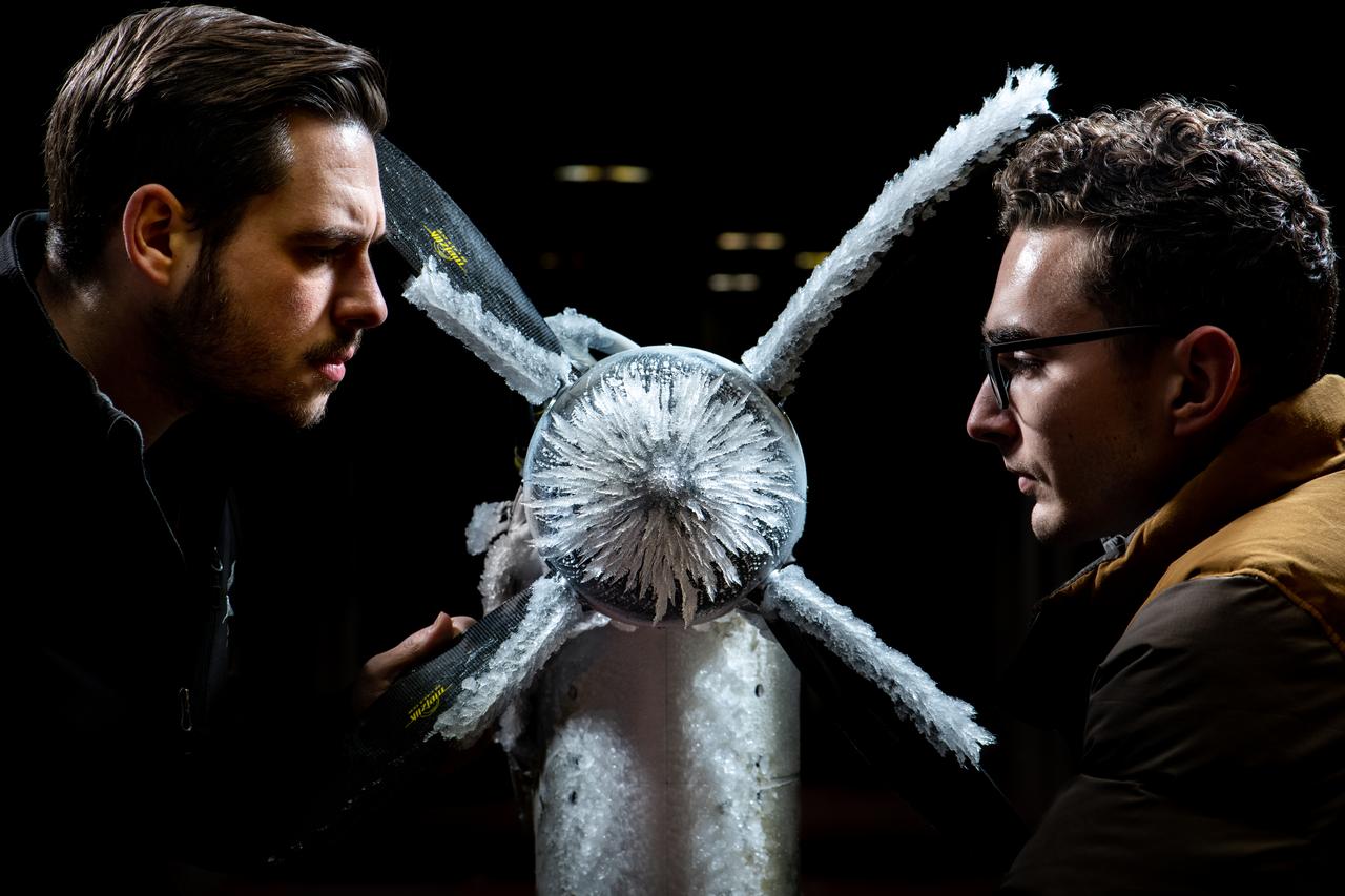 Curtis Flack (left) and Paul von Hardenberg (right) inspect the ice formation on the spinner of an Advanced Air Mobility proprotor model tested in the Icing Research Tunnel. The data from the test will be used by icing researchers to better understand the risks of icing on electric vertical takeoff and landing vehicles which will assist with the design and certification of new aircraft.