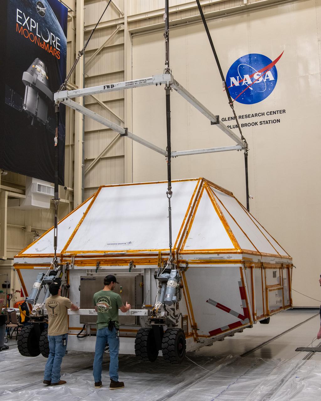 After the evening arrival of the Orion ETA (Environmental Test Article) having been shipped from Florida by truck, is shown being lowered to the floor of the Space Experiments Complex (SEC), Glenn Research Center, Armstrong Test Facility. The Orion ETA will undergo testing of the docking module jettison and the forward by cover jettison in preparation of the Artemis II launch.