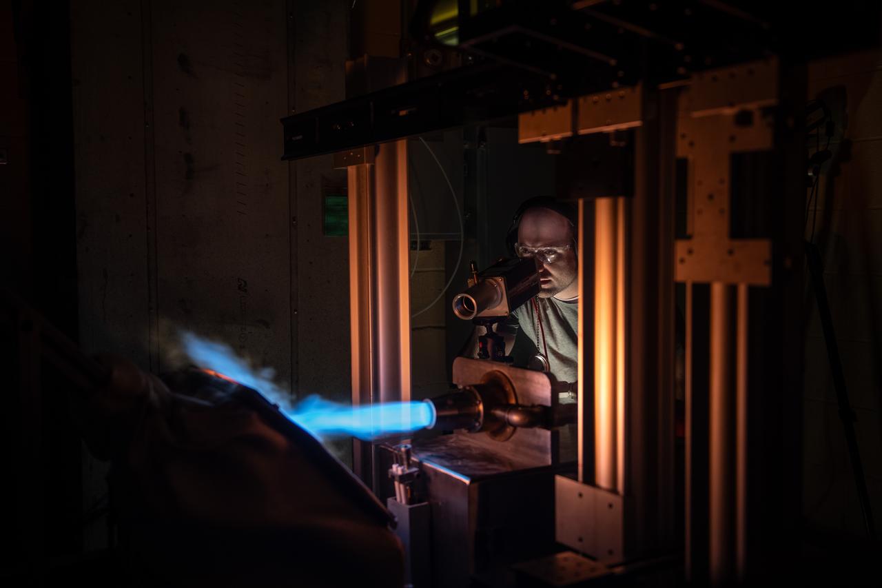 NASA Glenn’s Natural Gas/Oxygen Burner Rig is used to study the high temperature performance of various metal alloys, ceramics, and protective coatings for aero and space propulsion systems. The burner rig provides an easily accessible and economical method to simulate engine operating conditions to understand thermomechanical and thermochemical degradation of materials and structures. In the photo, Materials Research Engineer Michael Presby uses an infrared pyrometer to monitor the surface temperature of the material for a test on February 23, 2024. Photo Credit: (NASA/Sara Lowthian-Hanna)