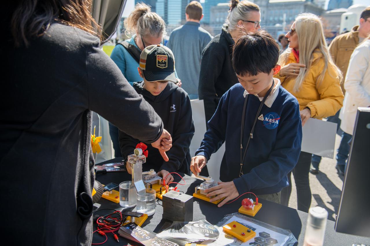 An event attendee interacts with a booth science activity at the Total Eclipse Fest at the Great Lakes Science Center in Cleveland, OH on April 7, 2024. A total solar eclipse swept across a narrow portion of the North American continent from Mexico’s Pacific coast to the Atlantic coast of Newfoundland, Canada. A partial solar eclipse was visible across the entire North American continent along with parts of Central America and Europe. Photo Credit: (NASA/Jef Janis)