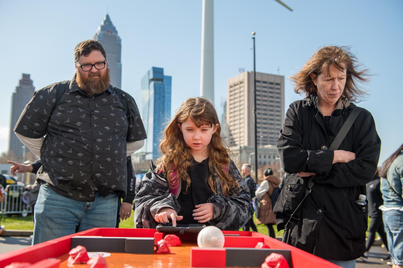 Event attendees interact with one of the hands on science activities on April 8, 2024. NASA Glenn Research Center and the Great Lakes Science Center hosted a three-day celestial celebration in downtown Cleveland, OH. This free, outdoor, family-friendly science and arts festival will feature free concerts, performances, speakers, and hands-on science activities with community partners. Photo Credit: (NASA/Jef Janis)