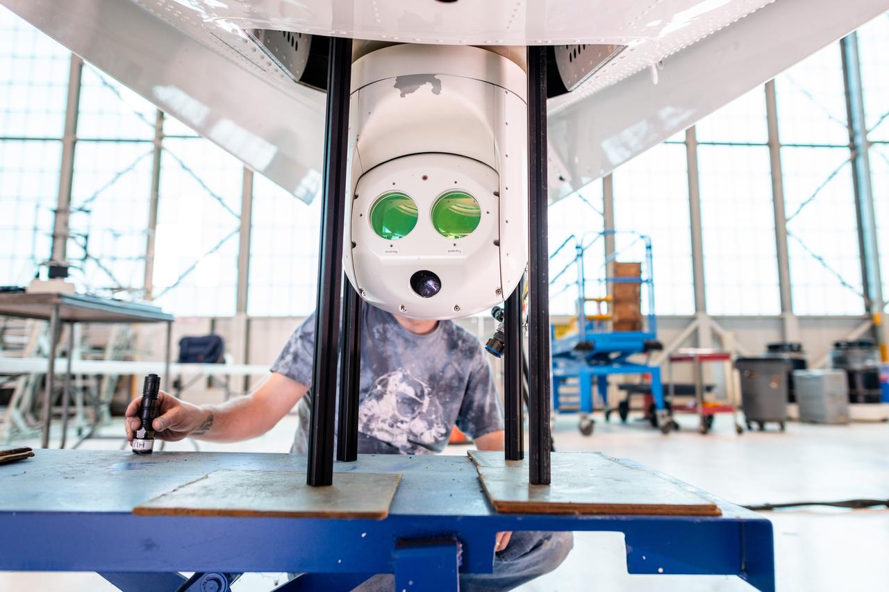 Dave Brennen, an electronics technician, installing the optical system under the belly of the PC-12 aircraft that streamed the first 4K video from aircraft to the International Space Station and back on May 20, 2024. Photo Credit: (NASA/Sara Lowthian-Hanna)