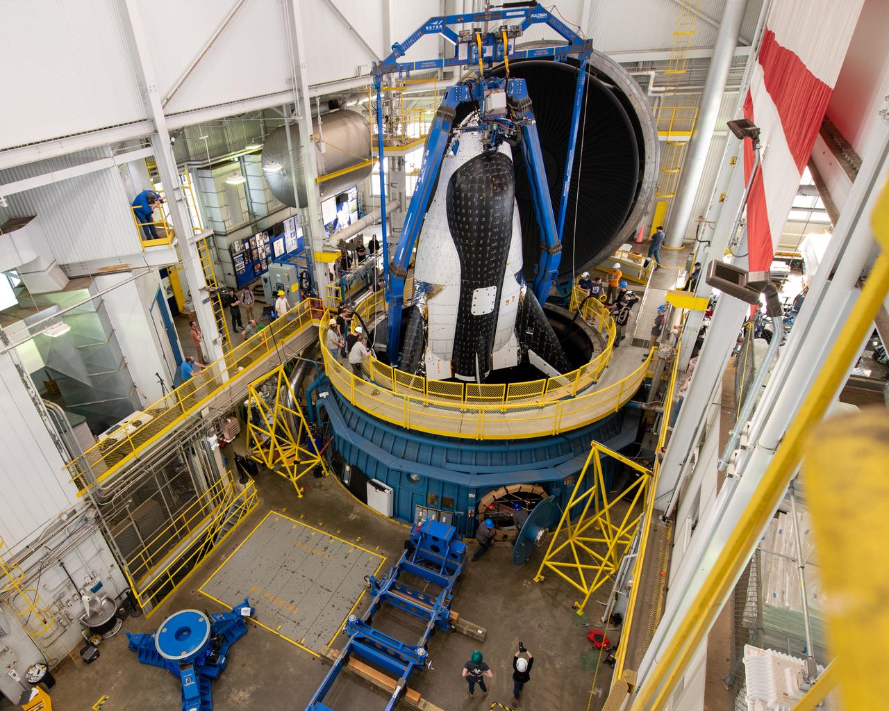 Sierra Space Dream Chaser space plane is lifted into the chamber at ISP (In Space Propulsion) facility, building 3211 at ATF (Armstrong Test Facility) for environmental testing.  Once lowered into the test chamber, it will be exposed to the harsh cold conditions of space for extended periods of time.