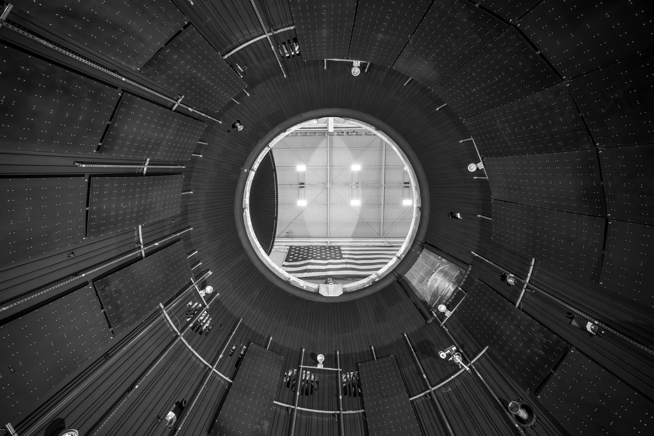 NASA’s In-Space Propulsion Facility located at Neil Armstrong Test Facility in Sandusky Ohio is the world’s only high altitude test facility capable of full-scale rocket engine and launch vehicle system level tests. The facility supports mission profile thermal vacuum simulation and engine firing. The engine or vehicle can be exposed for indefinite periods to low ambient pressures, low-background temperatures, and dynamic solar heating, simulating the environment the hardware will encounter during orbital or interplanetary travel.  This is a view from inside the chamber looking up toward the American flag. Photo Credit: (NASA/Jordan Salkin)